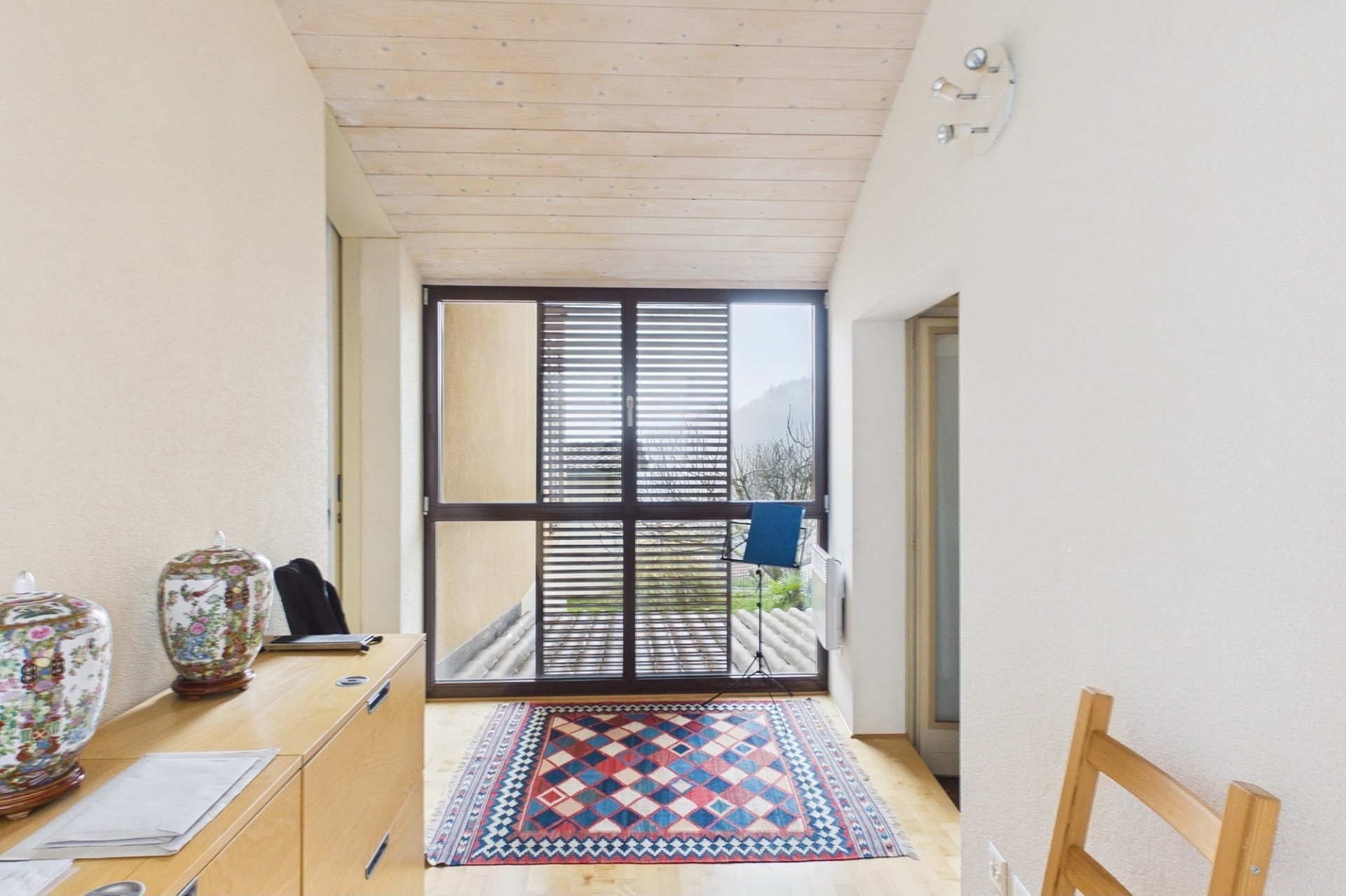 Heller Flur mit großer Fensterfront und Blick ins Grüne