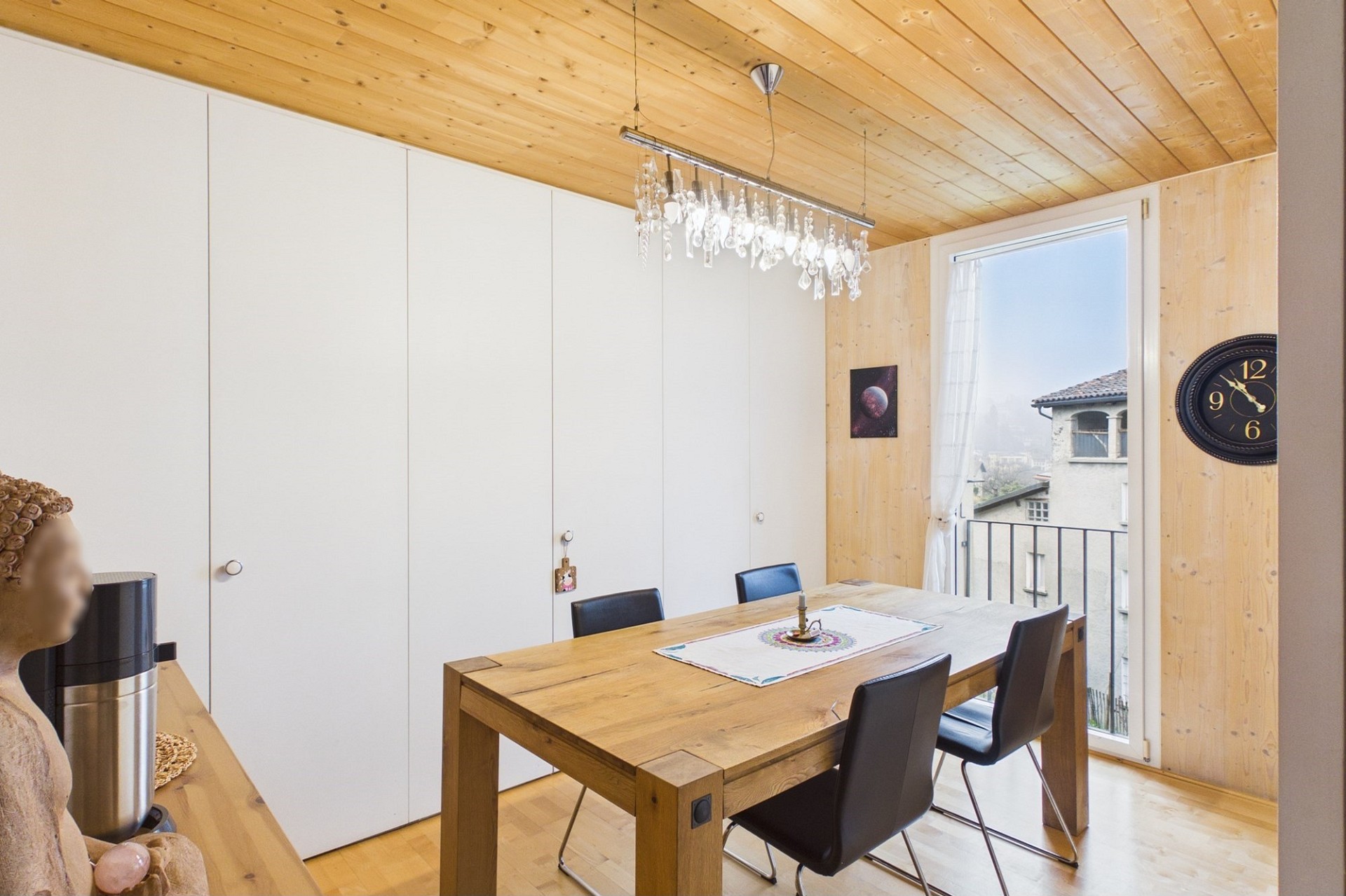 Esszimmer mit Holzverkleidung und Balkonblick