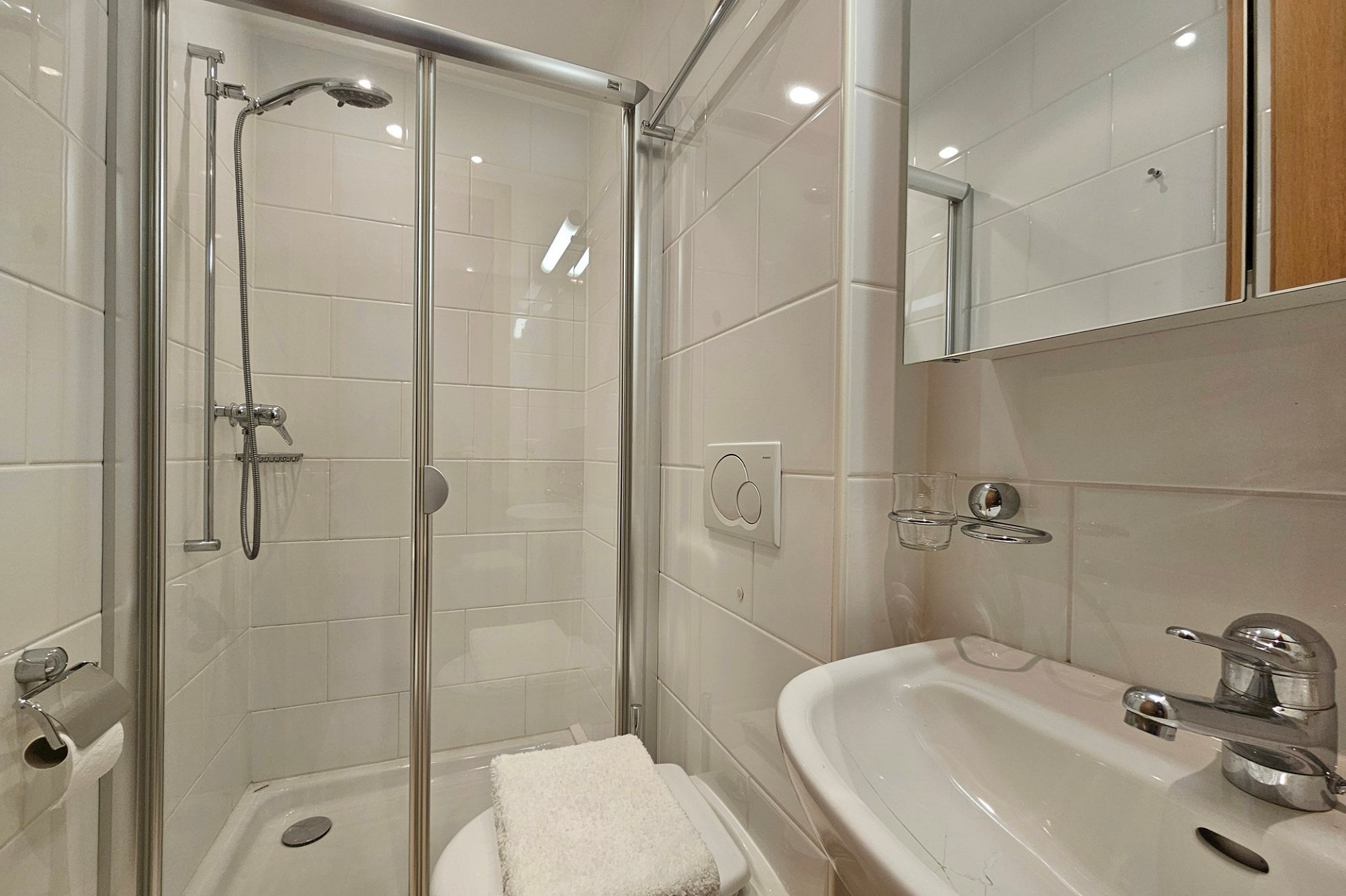 Kleines, helles Badezimmer mit Dusche und Waschbecken
