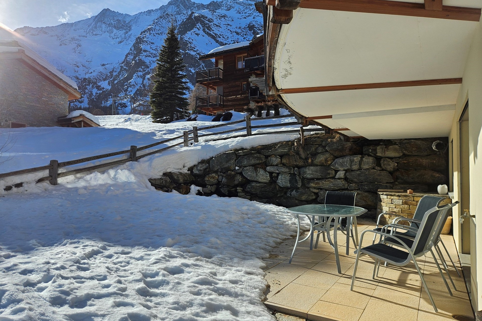 Sonnige Bergterrasse mit Schneeblick