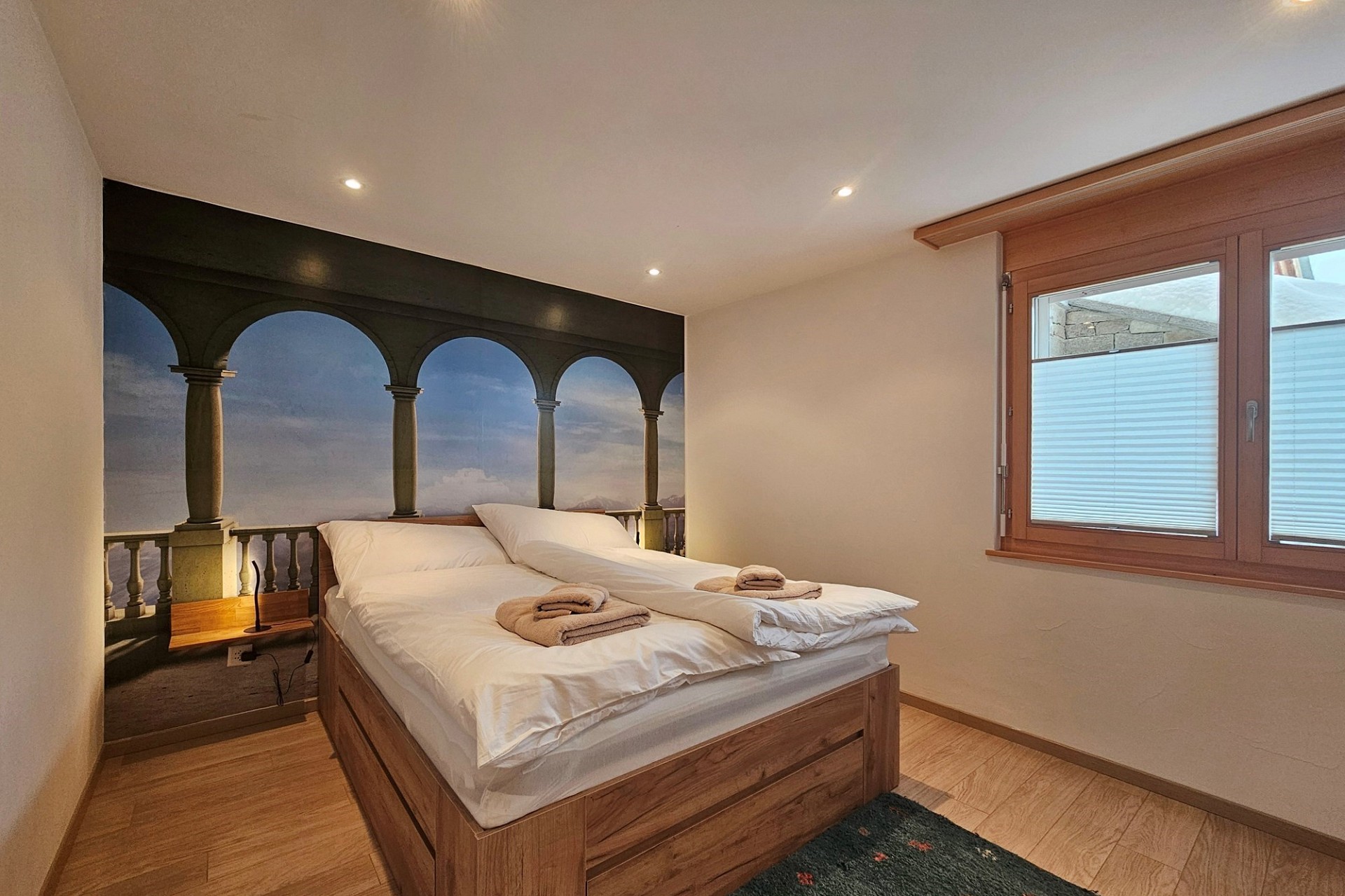 Schlafzimmer mit Doppelbett und Wandbild