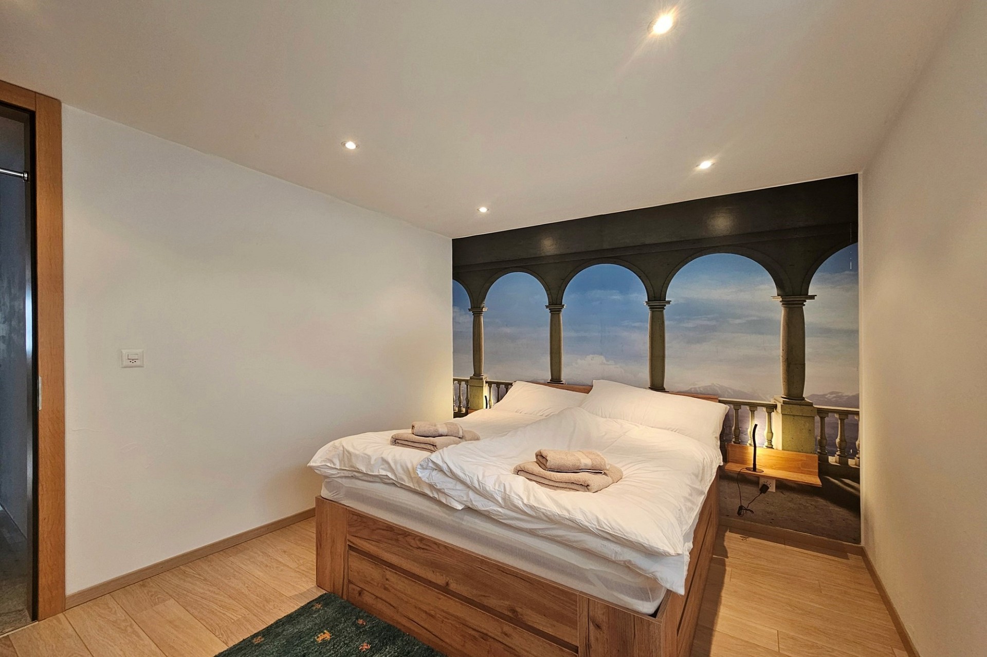 Schlafzimmer mit Doppelbett und Wandmotiv