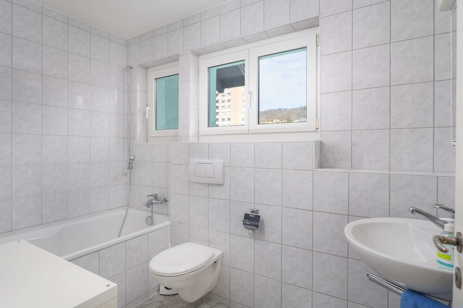 Helles Badezimmer mit Badewanne, WC und Waschtisch