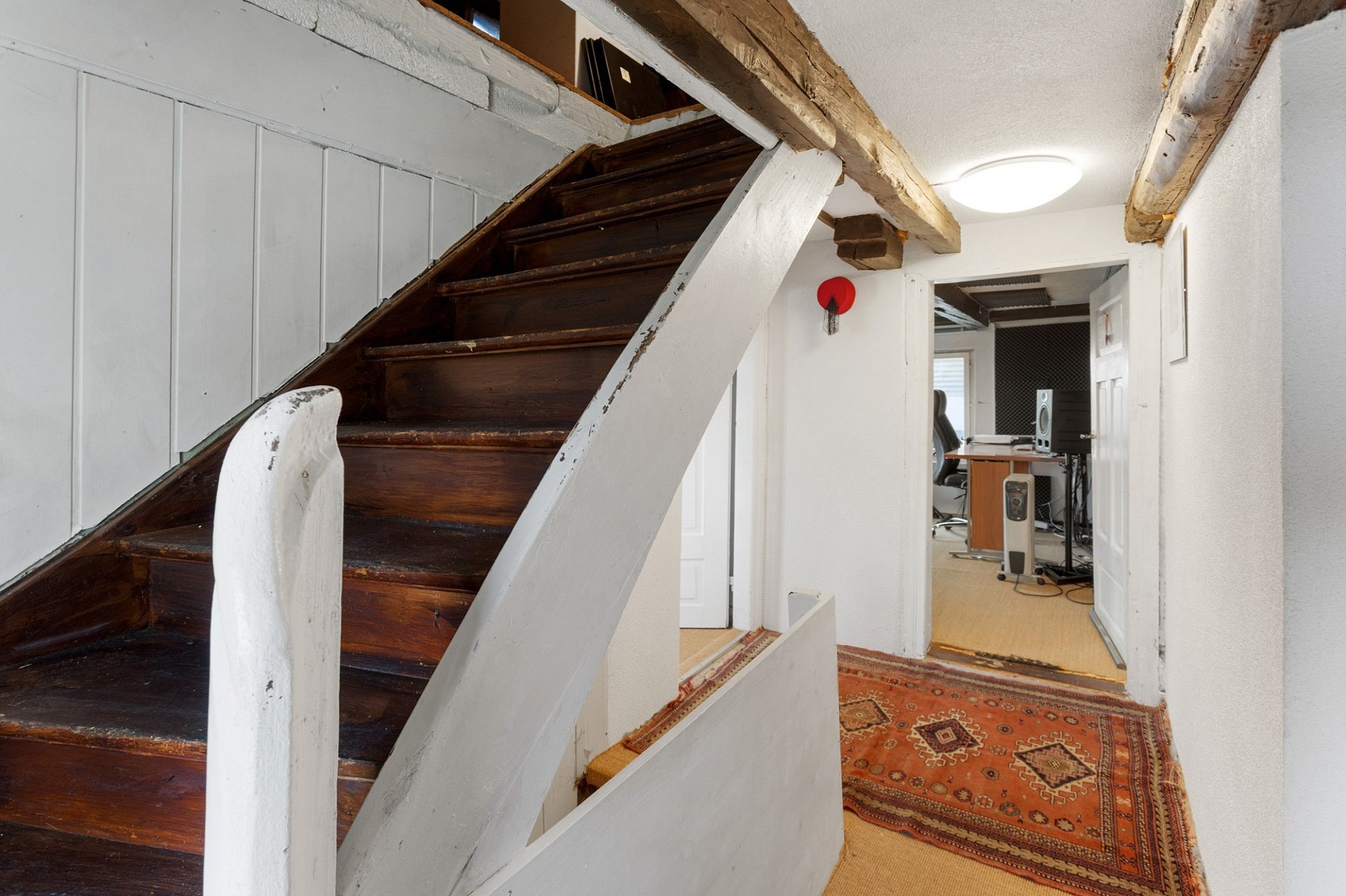 Treppenhaus mit sichtbaren Holzbalken