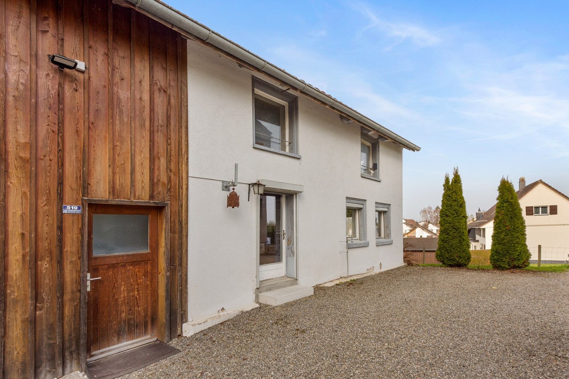 Außenansicht eines Wohnhauses mit Holzverschalung und weißer Fassade