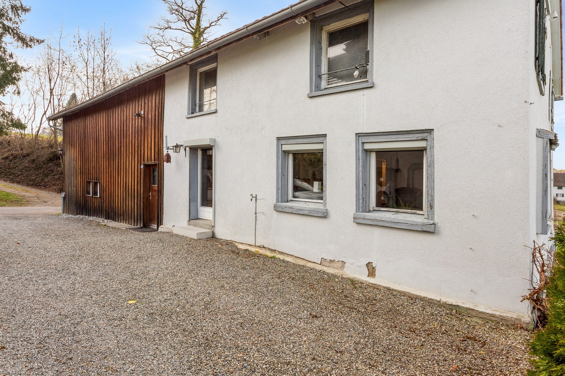 Älteres Wohnhaus mit Holzverschalung und weiß verputzter Fassade