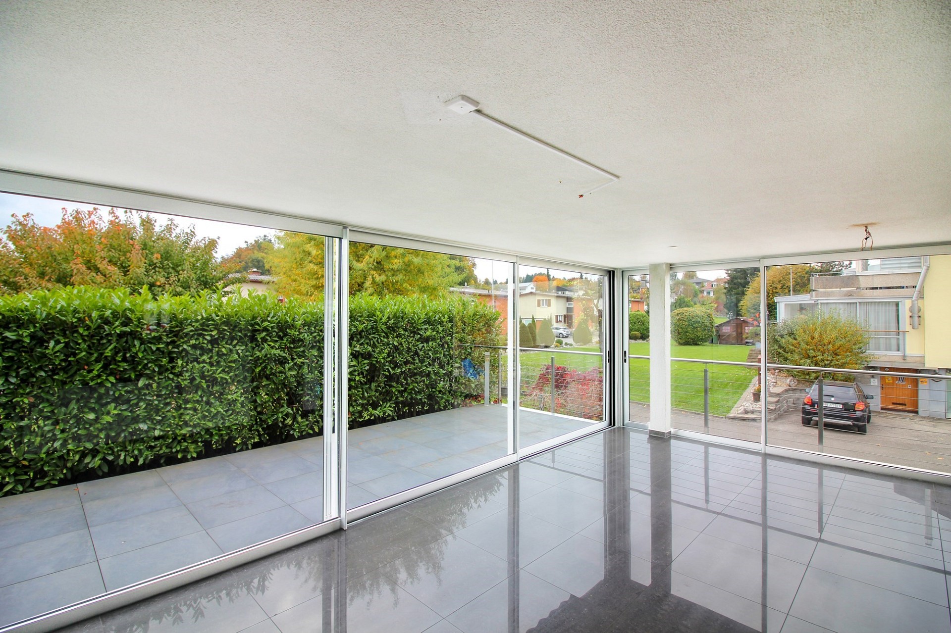 Heller verglaster Wohnraum mit großer Terrasse