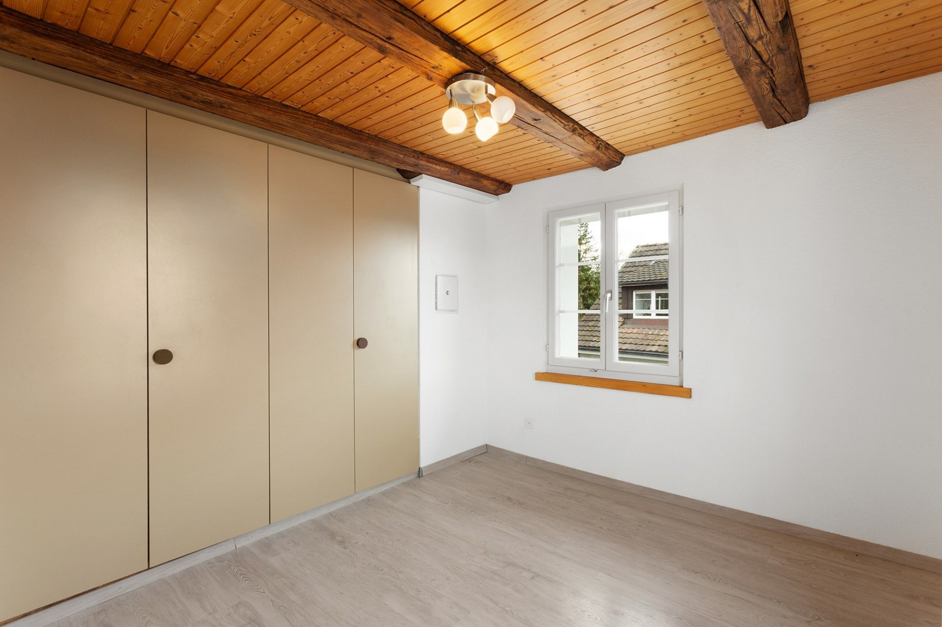 Helles Zimmer mit Holzdecke und Einbauschrank