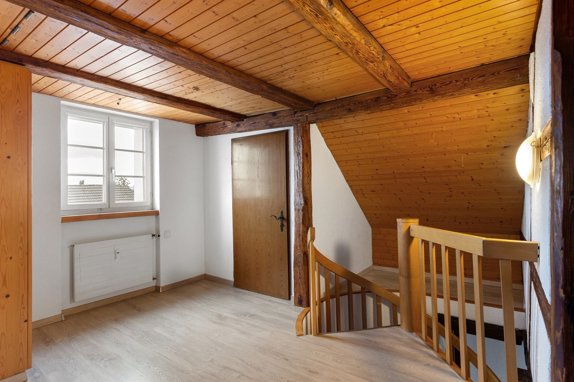 Heller Dachboden- bzw. Treppenbereich mit Holzdecke und Geländer