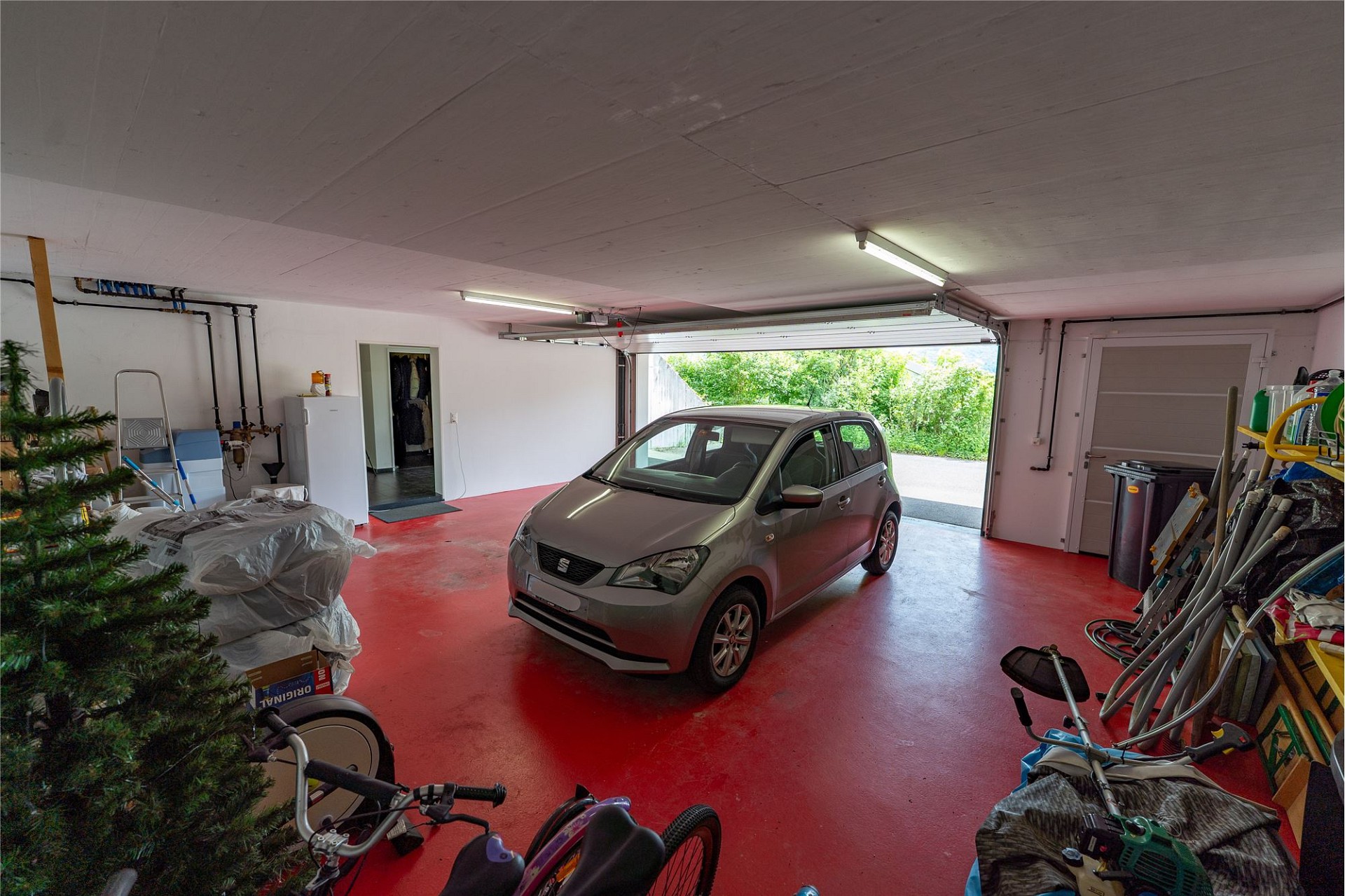 Garage mit geparktem Kleinwagen und offenem Tor