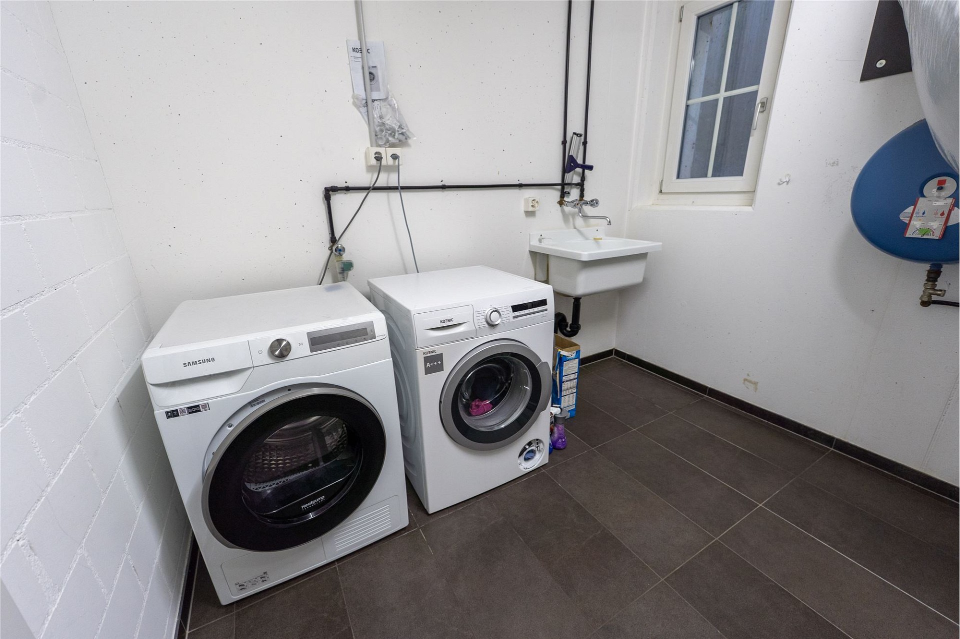 Hauswirtschaftsraum mit Waschmaschine und Waschtrog
