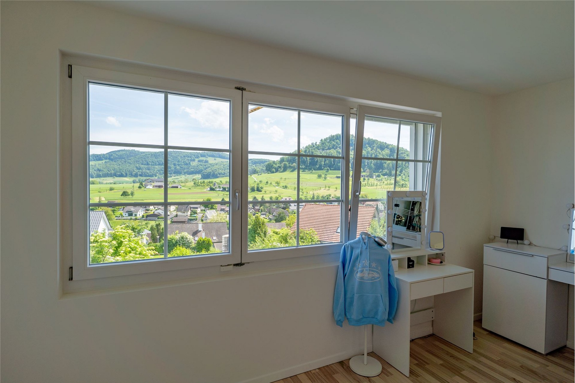 Schlafzimmer mit Panoramafenster und Aussicht ins Grüne