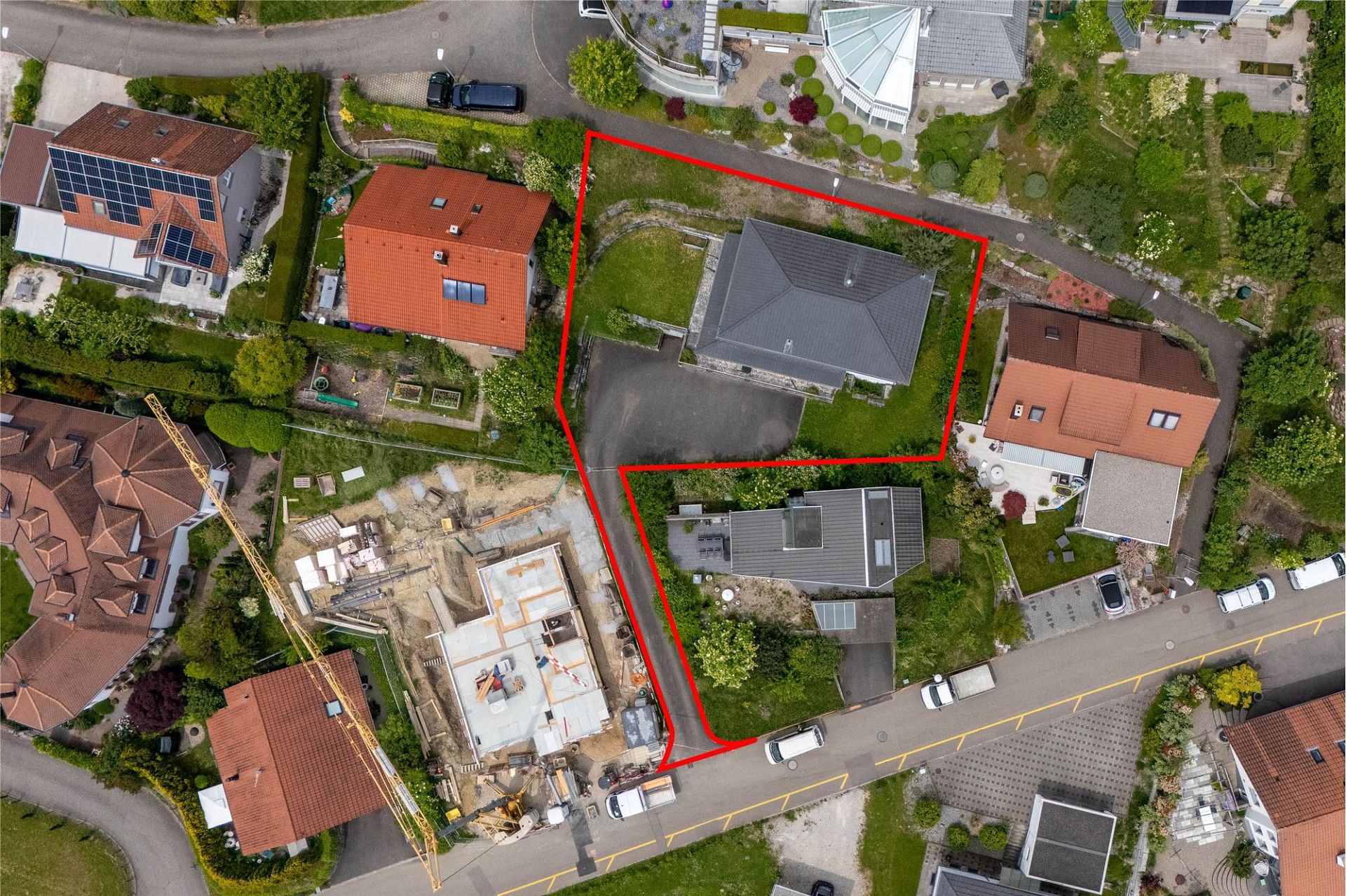 Luftaufnahme eines markierten Grundstücks mit Wohnhaus und Umgebung