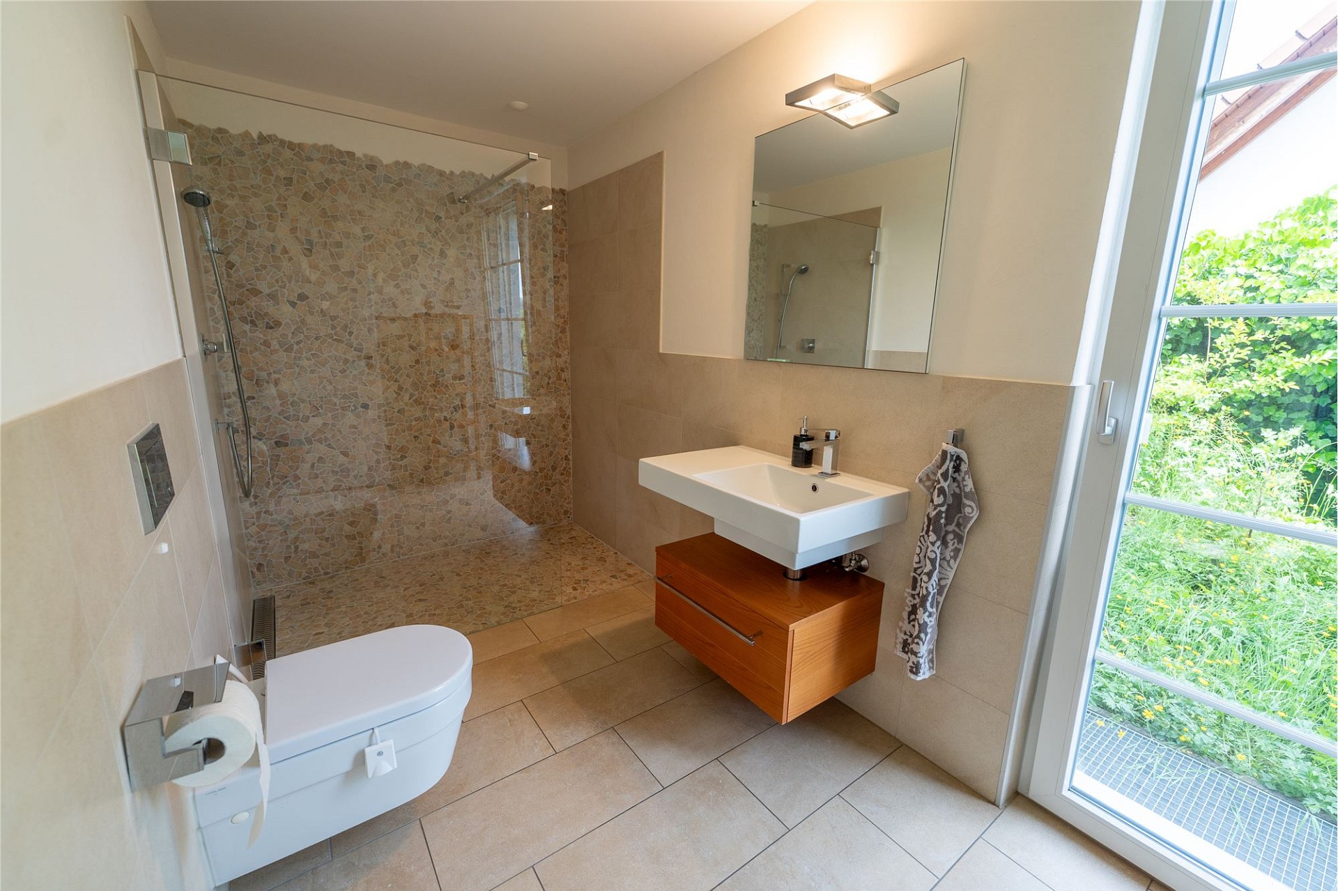 Modernes Badezimmer mit Dusche und Gartenblick