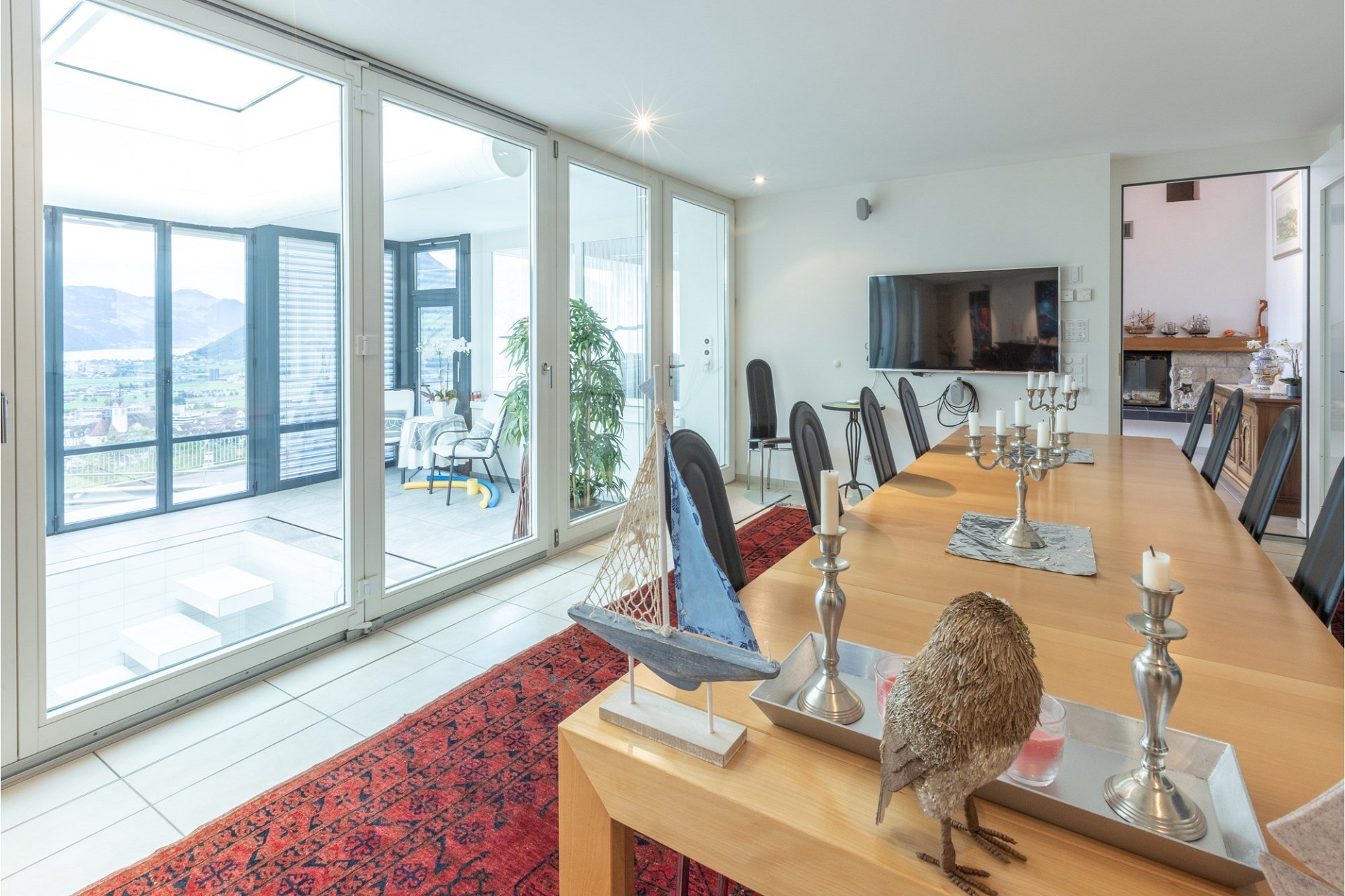 Helles Esszimmer mit Blick auf Berge und Wintergarten