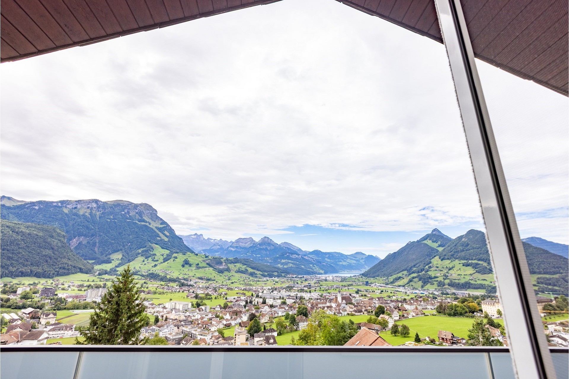 Alpen- und Stadtblick von einem Balkon