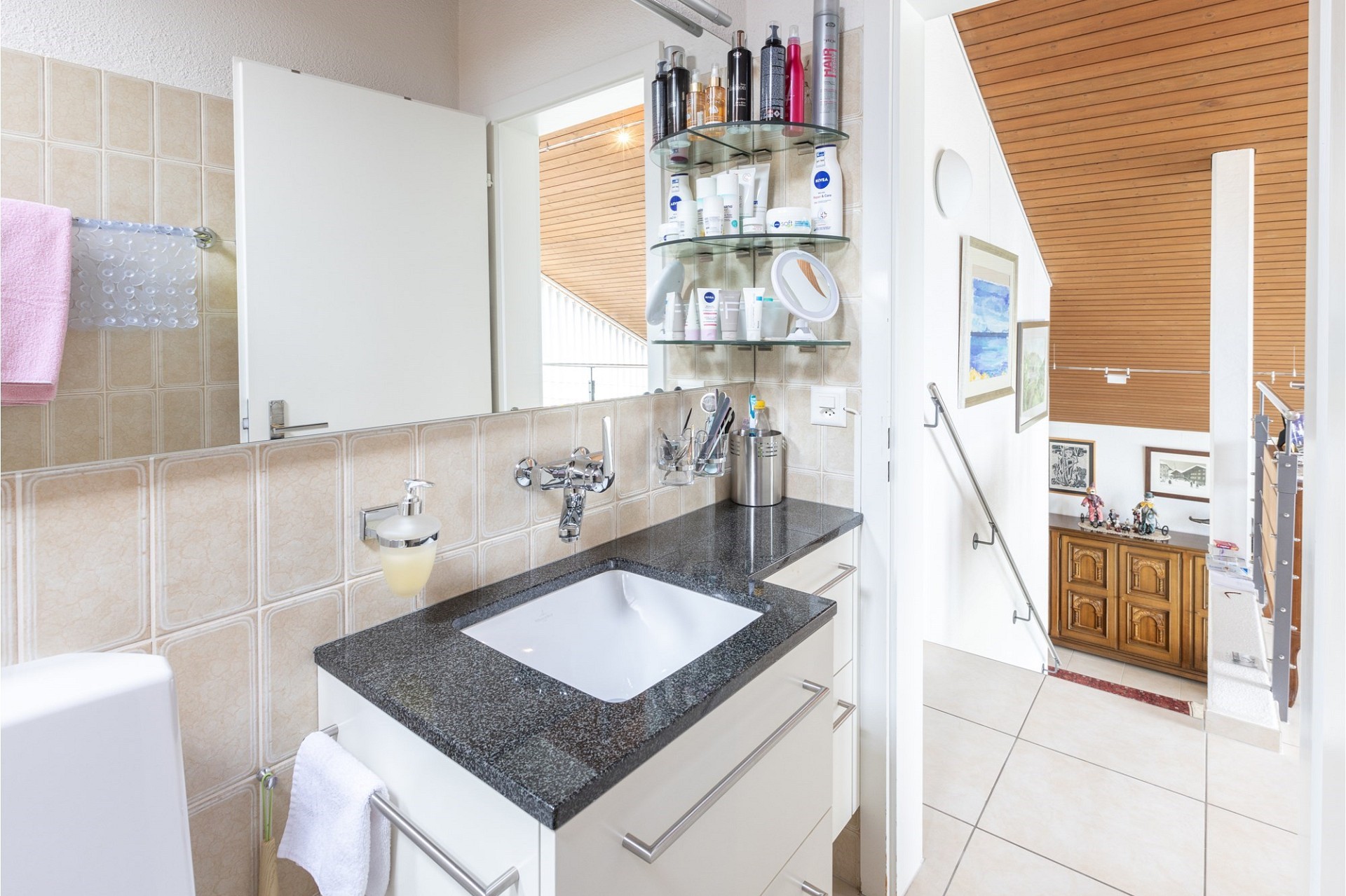Helles Badezimmer mit Waschplatz und Treppenblick