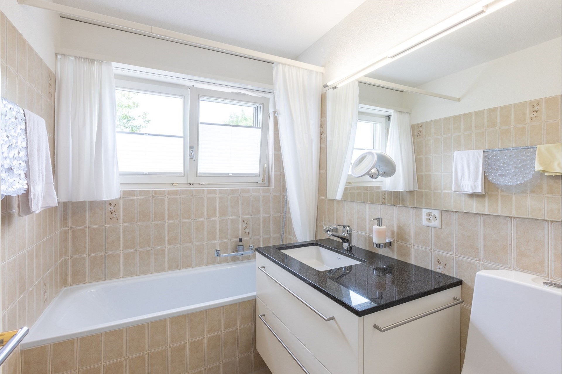 Helles Badezimmer mit Badewanne und Waschtisch