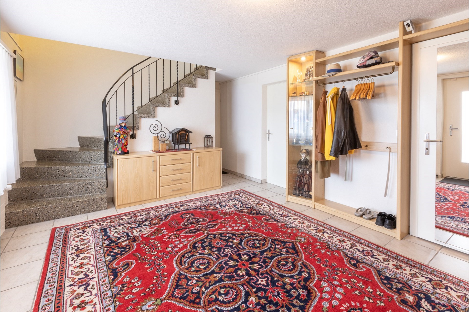 Heller Eingangsbereich mit Treppe und Garderobe