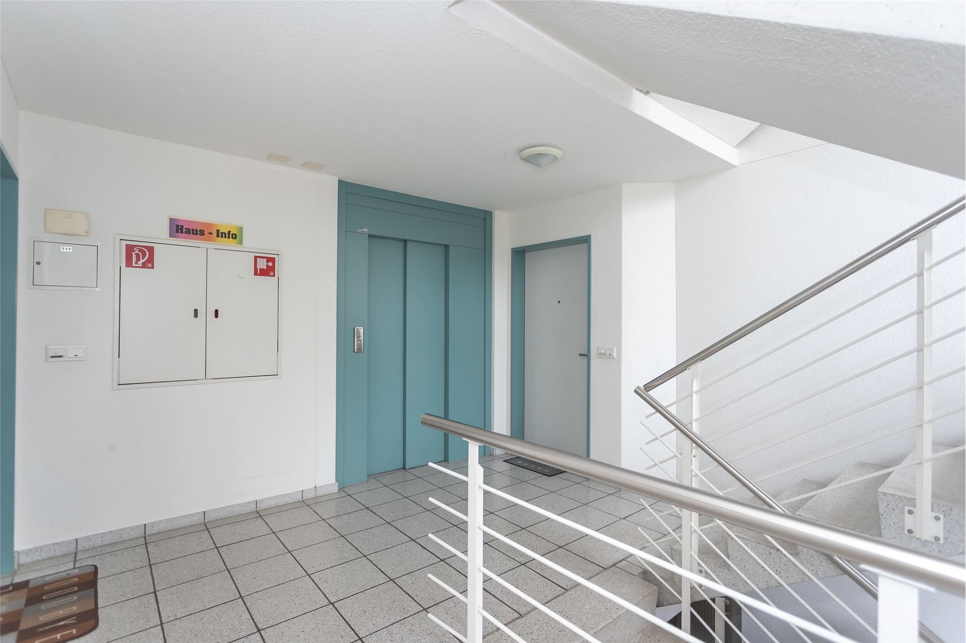 Treppenhaus mit Aufzug und Haus-Info