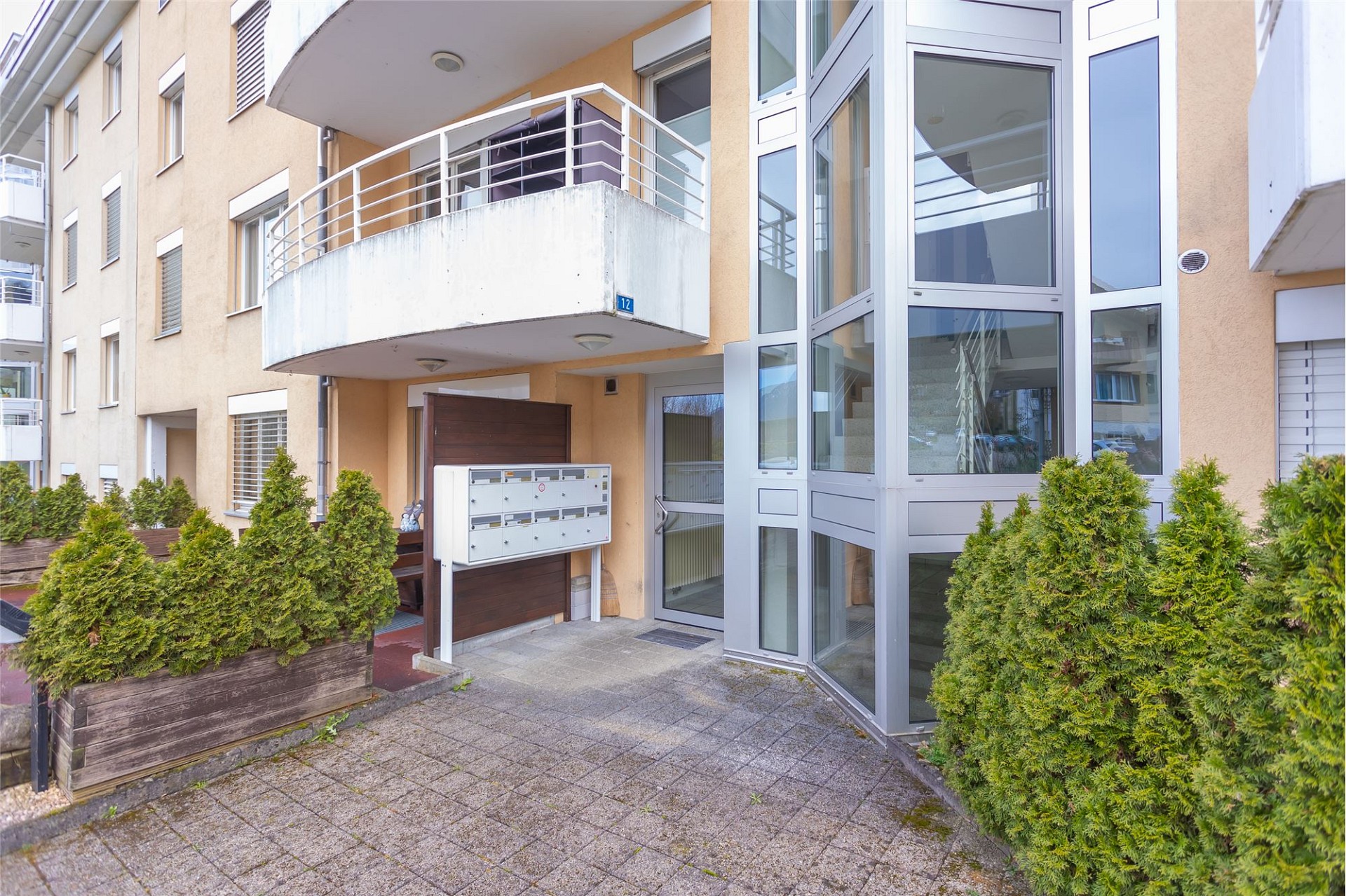 Außenansicht eines Wohngebäudes mit Balkon und Eingang