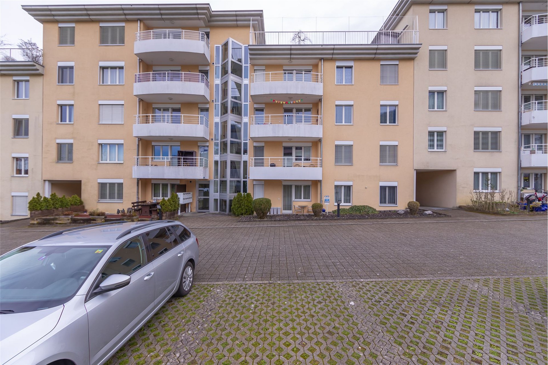 Mehrfamilienhaus mit Balkonen und Innenhofzufahrt