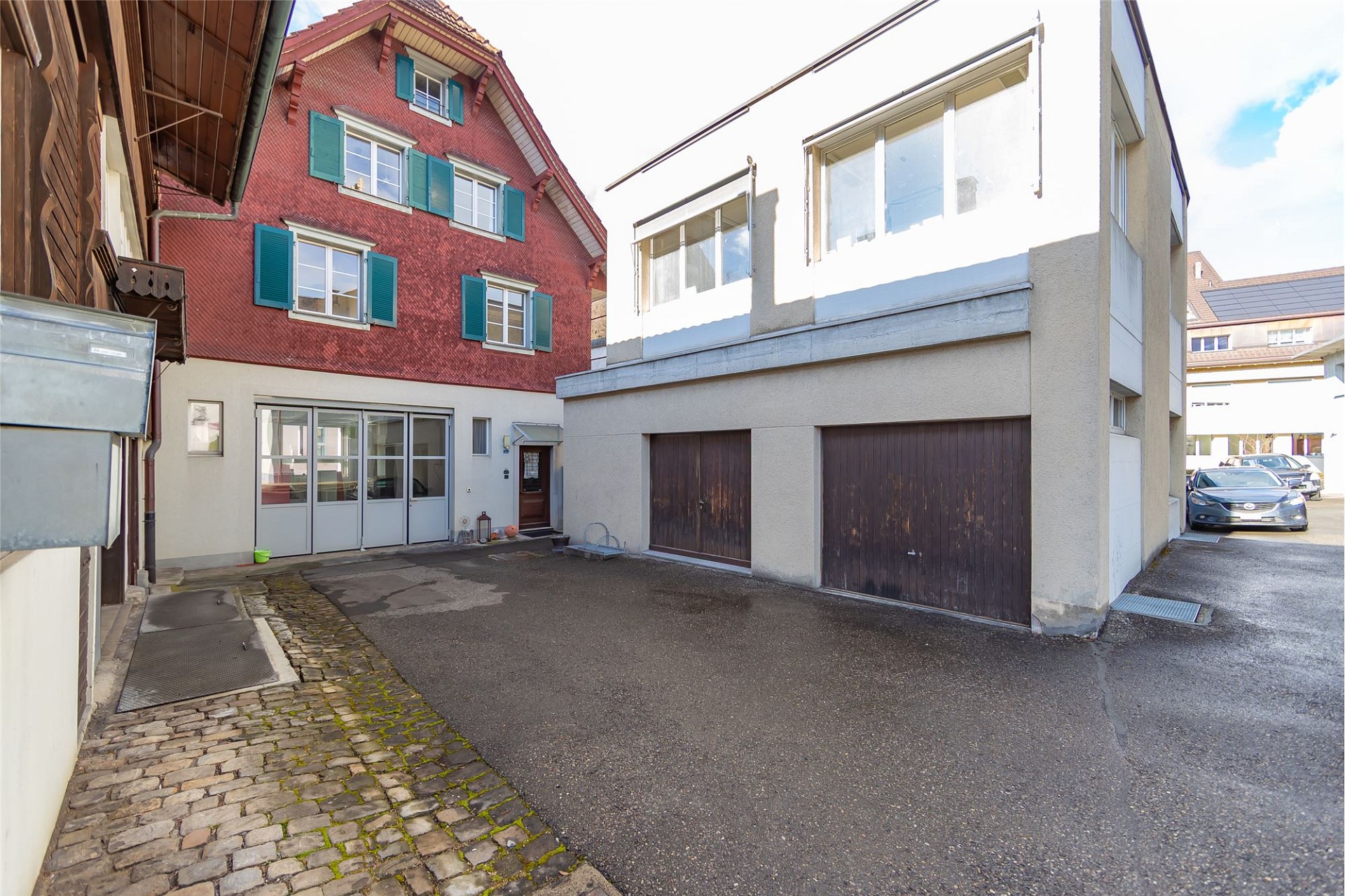 Innenhof mit zwei Wohngebäuden und Garagen