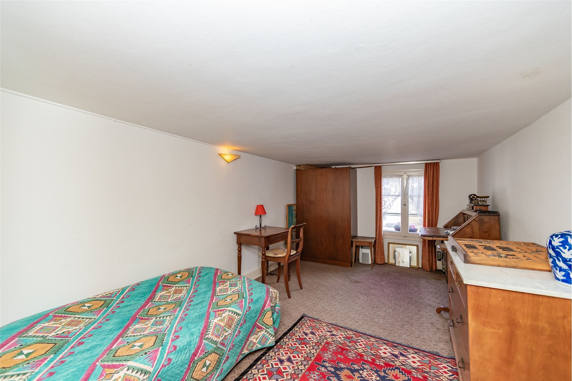 Schlichtes, möbliertes Schlafzimmer mit Dachschräge