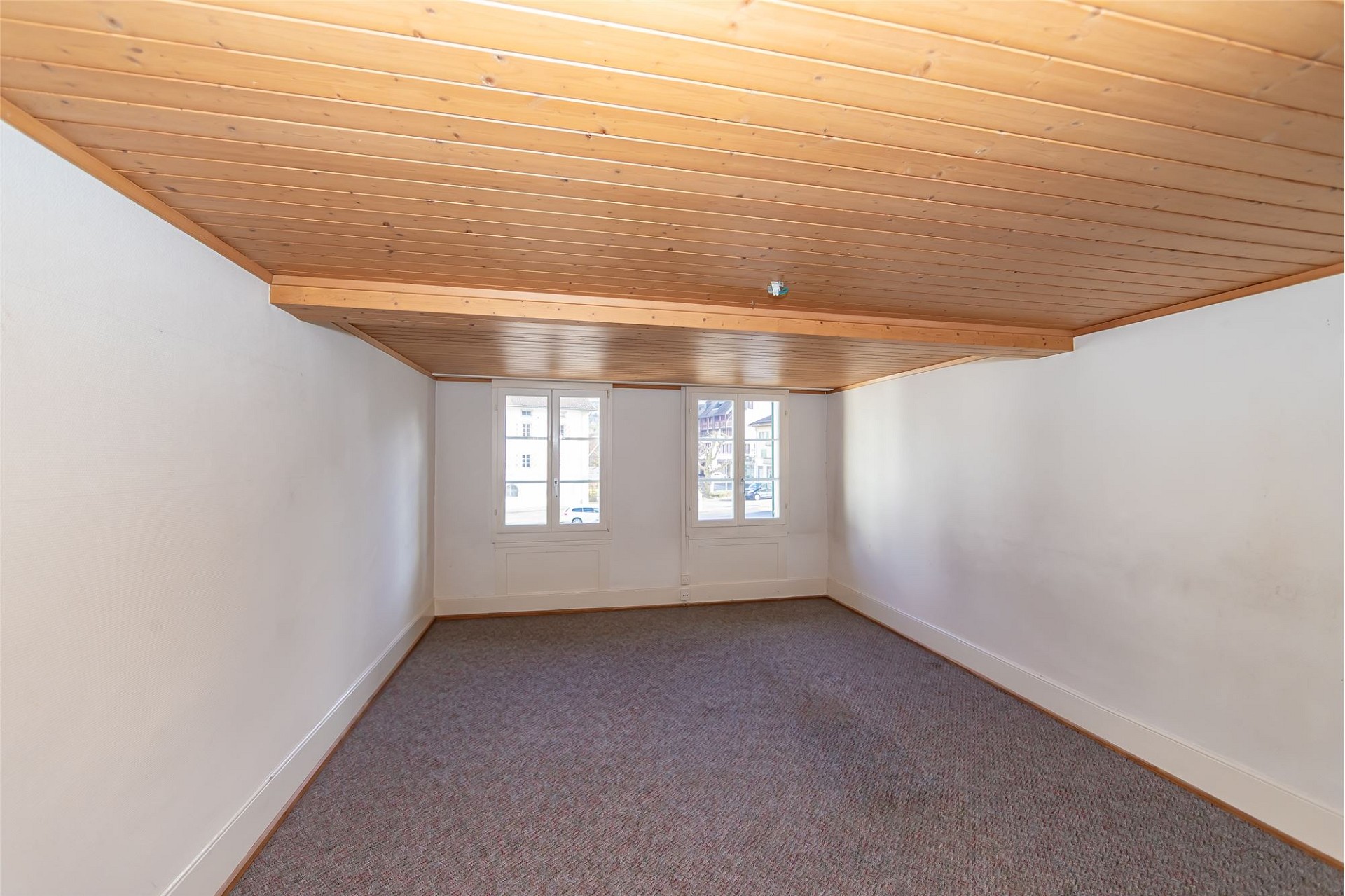Leerer Dachraum mit Holzdecke und Teppichboden