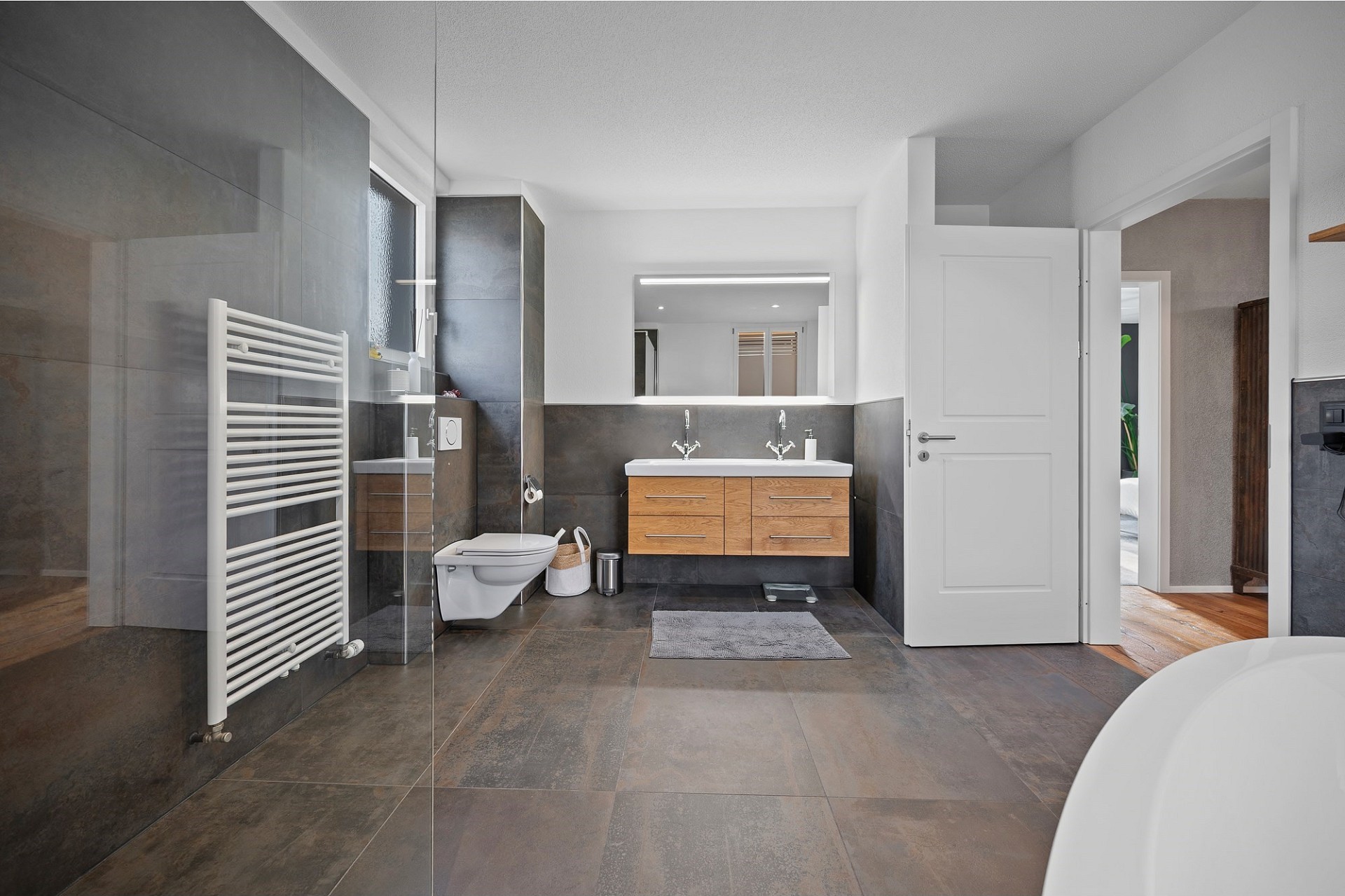 Modernes Badezimmer mit dunklen Fliesen und Holz-Waschtisch