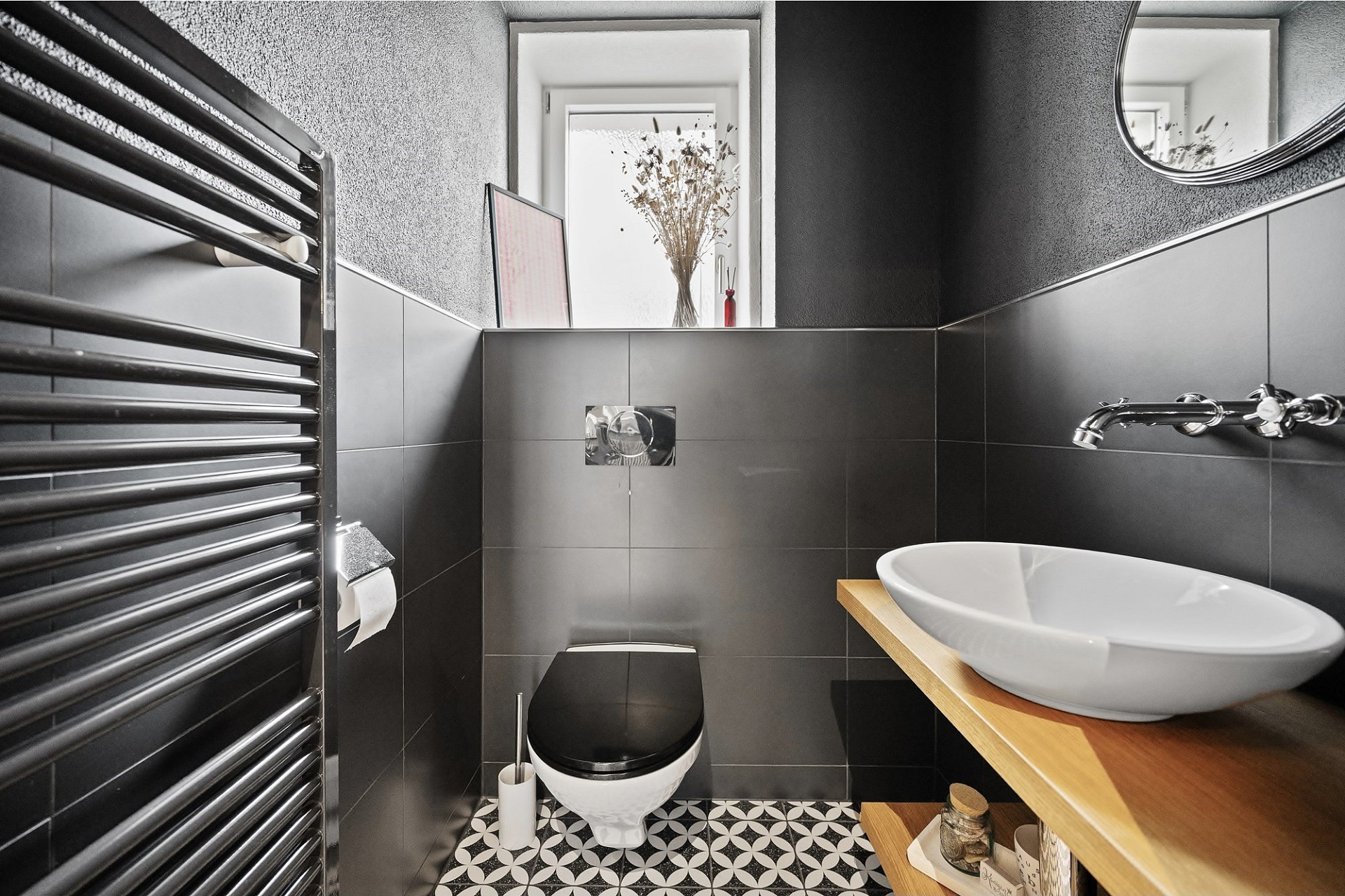 Modernes Gäste-WC mit schwarzen Fliesen und rundem Aufsatzwaschbecken