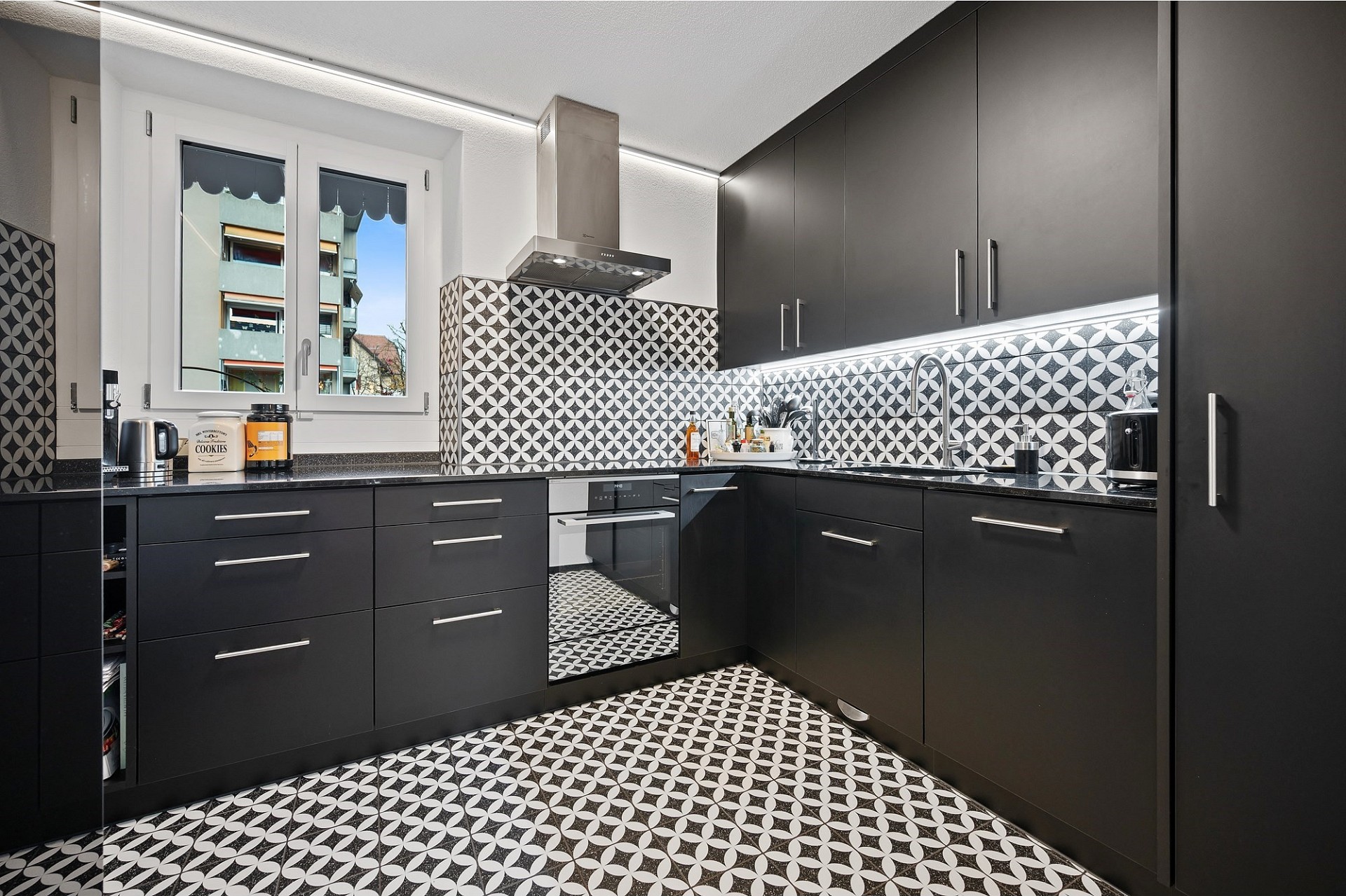 Moderne schwarze Küche mit geometrischem Fliesenmuster