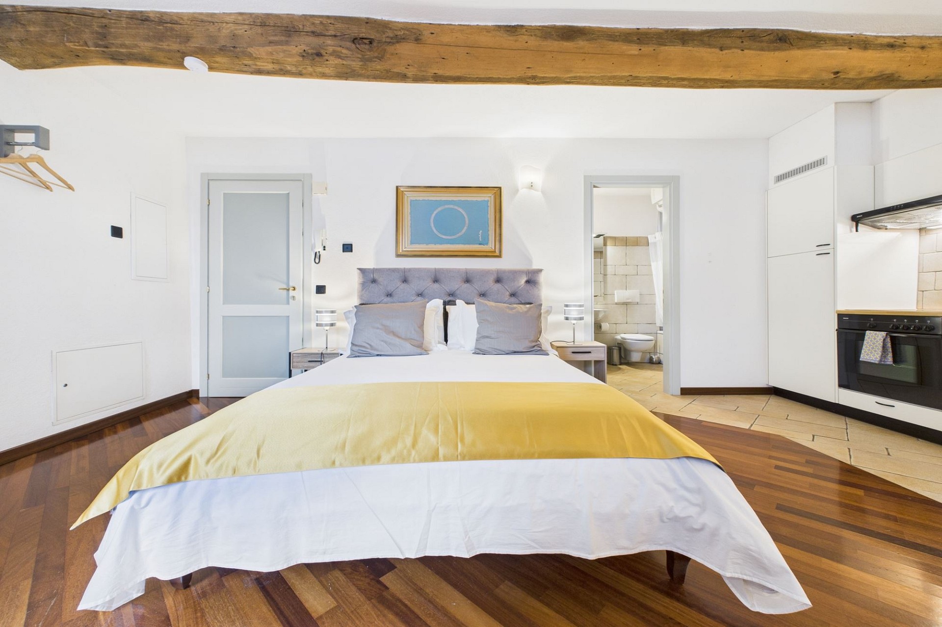 Schlafzimmer mit offener Küchenzeile und sichtbarem Badzugang