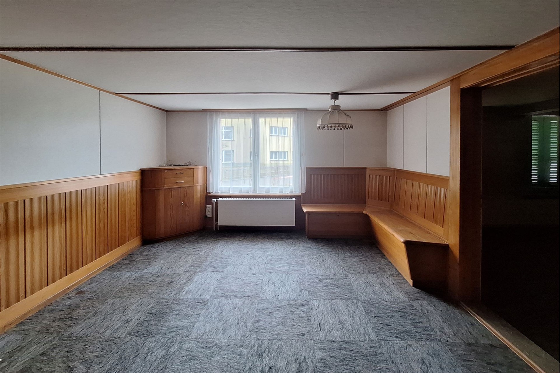 Wohnraum mit Holzvertäfelung und Teppichboden