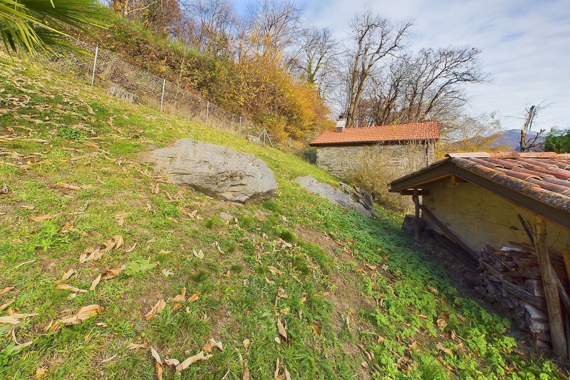 Hanglage mit Nebengebäude und Wiesenfläche