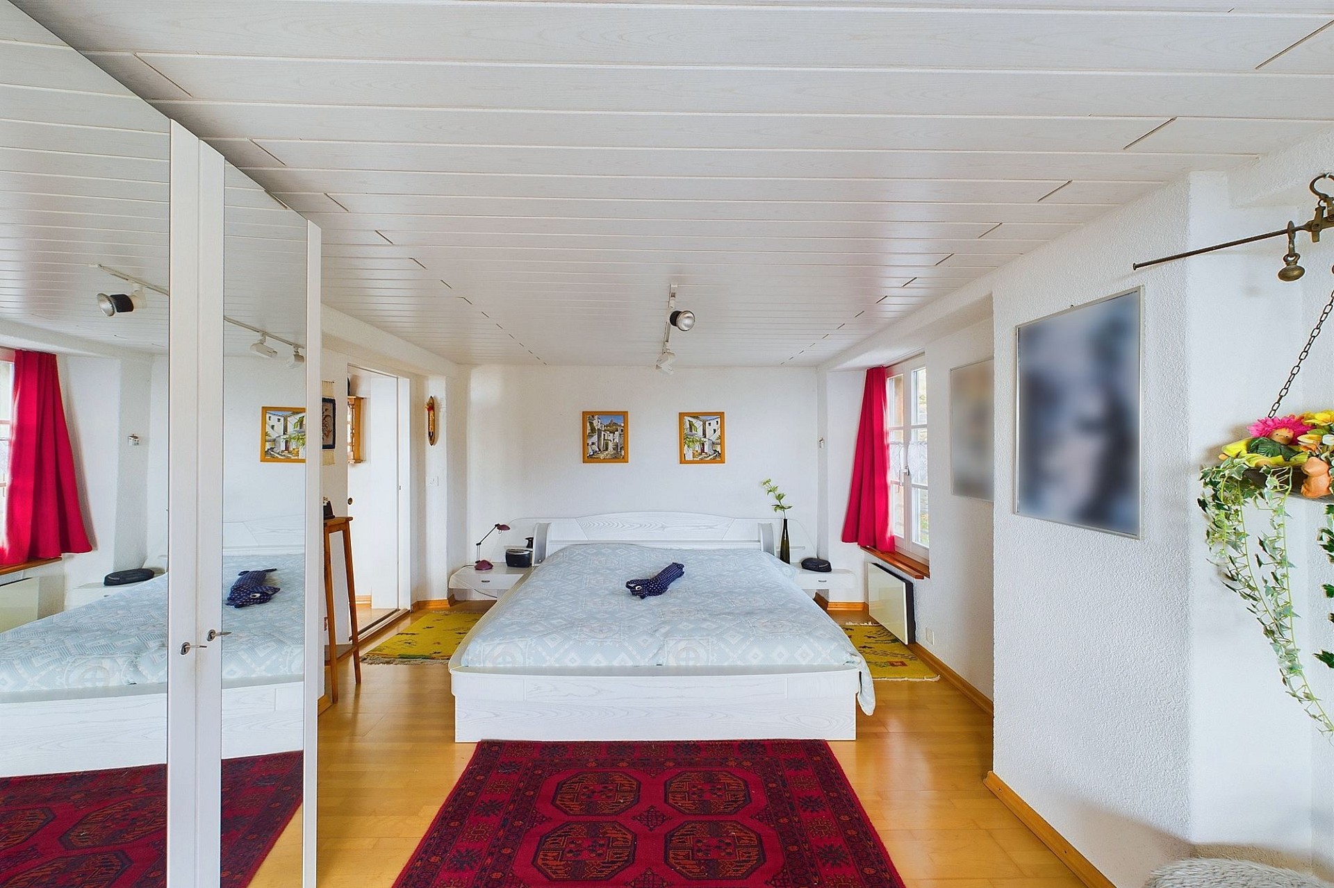 Helles Schlafzimmer mit Doppelbett und Spiegelwand