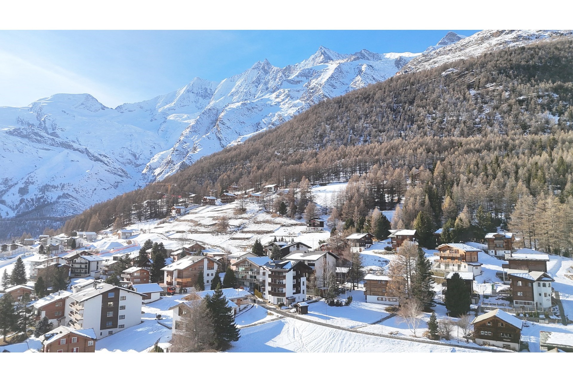 Schneebedecktes Bergdorf mit Alpenpanorama