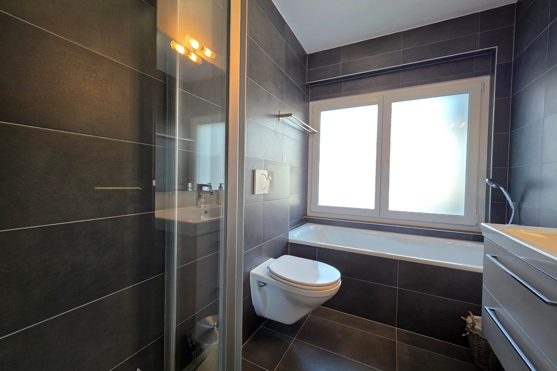 Modernes Badezimmer mit dunklen Fliesen