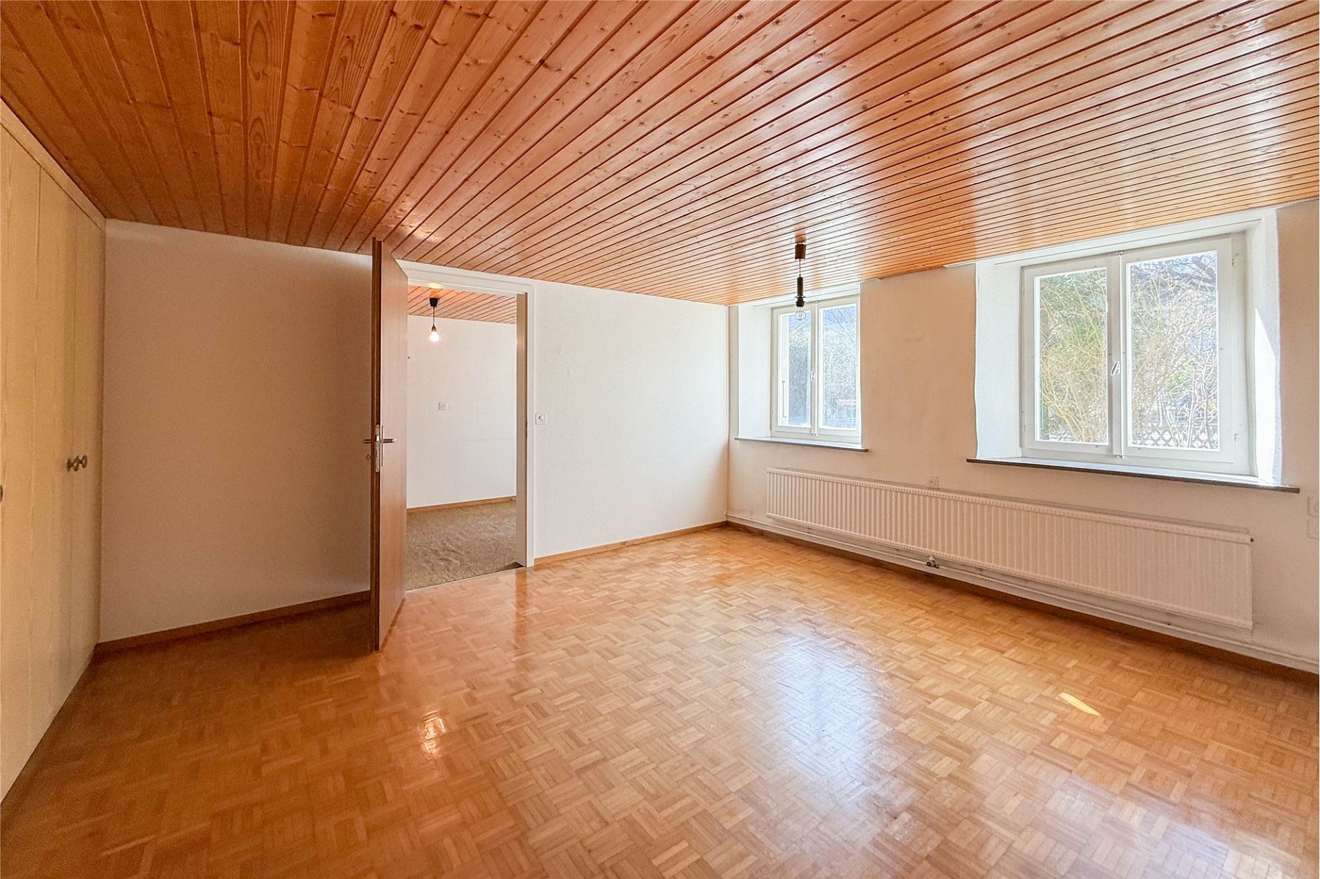 Leeres Zimmer mit Holzdecke und Parkettboden