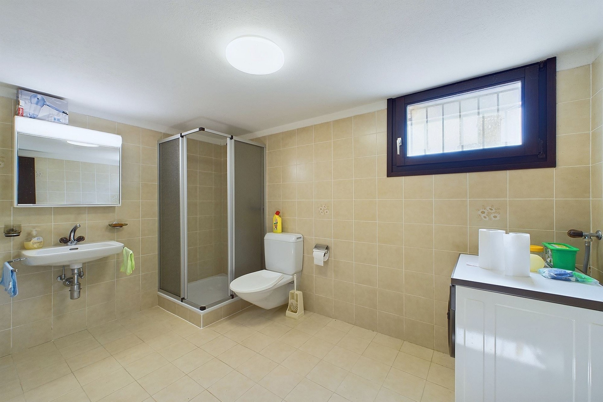 Beiges Badezimmer mit Dusche, WC und Fenster