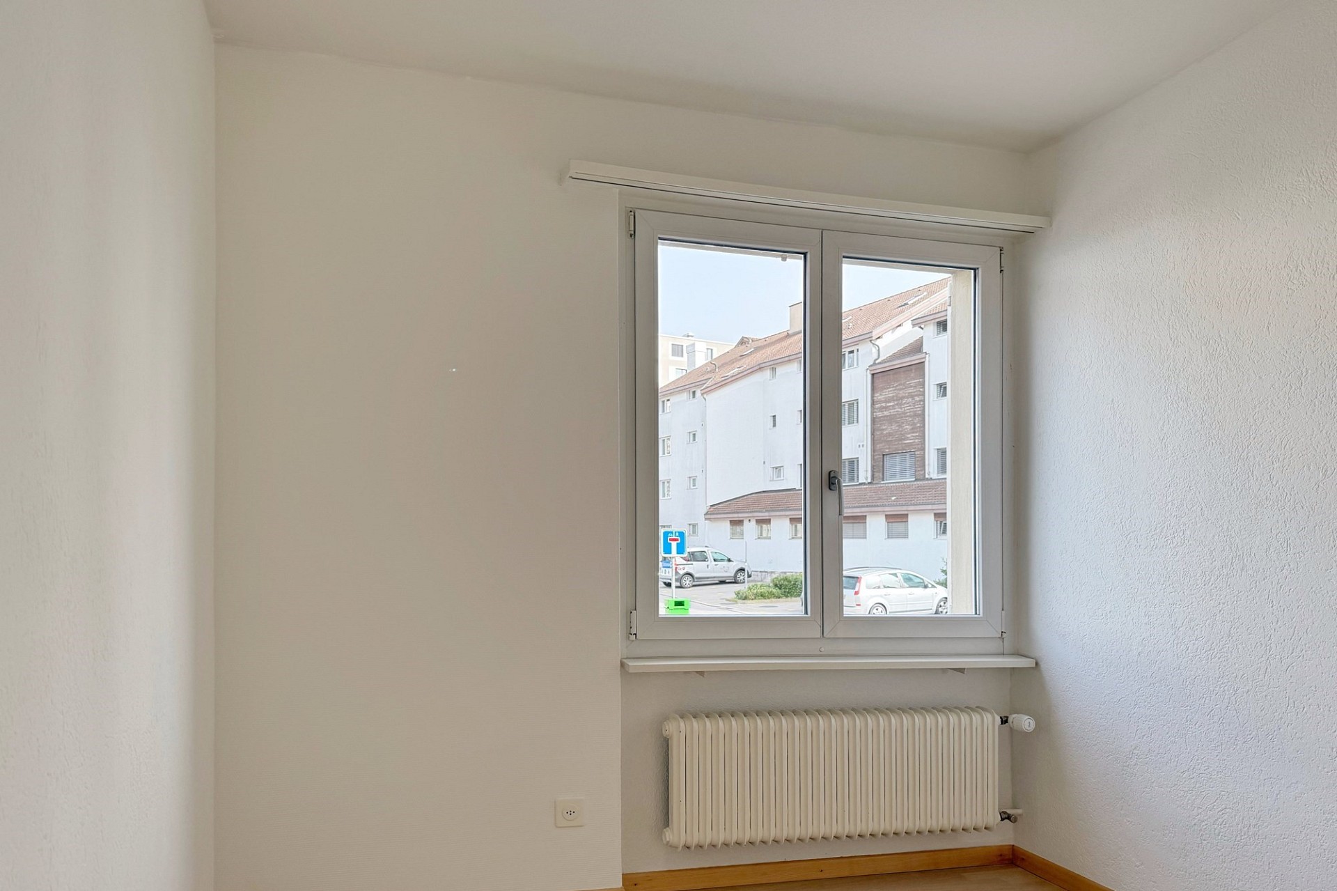 Helles leeres Zimmer mit Fenster und Heizkörper