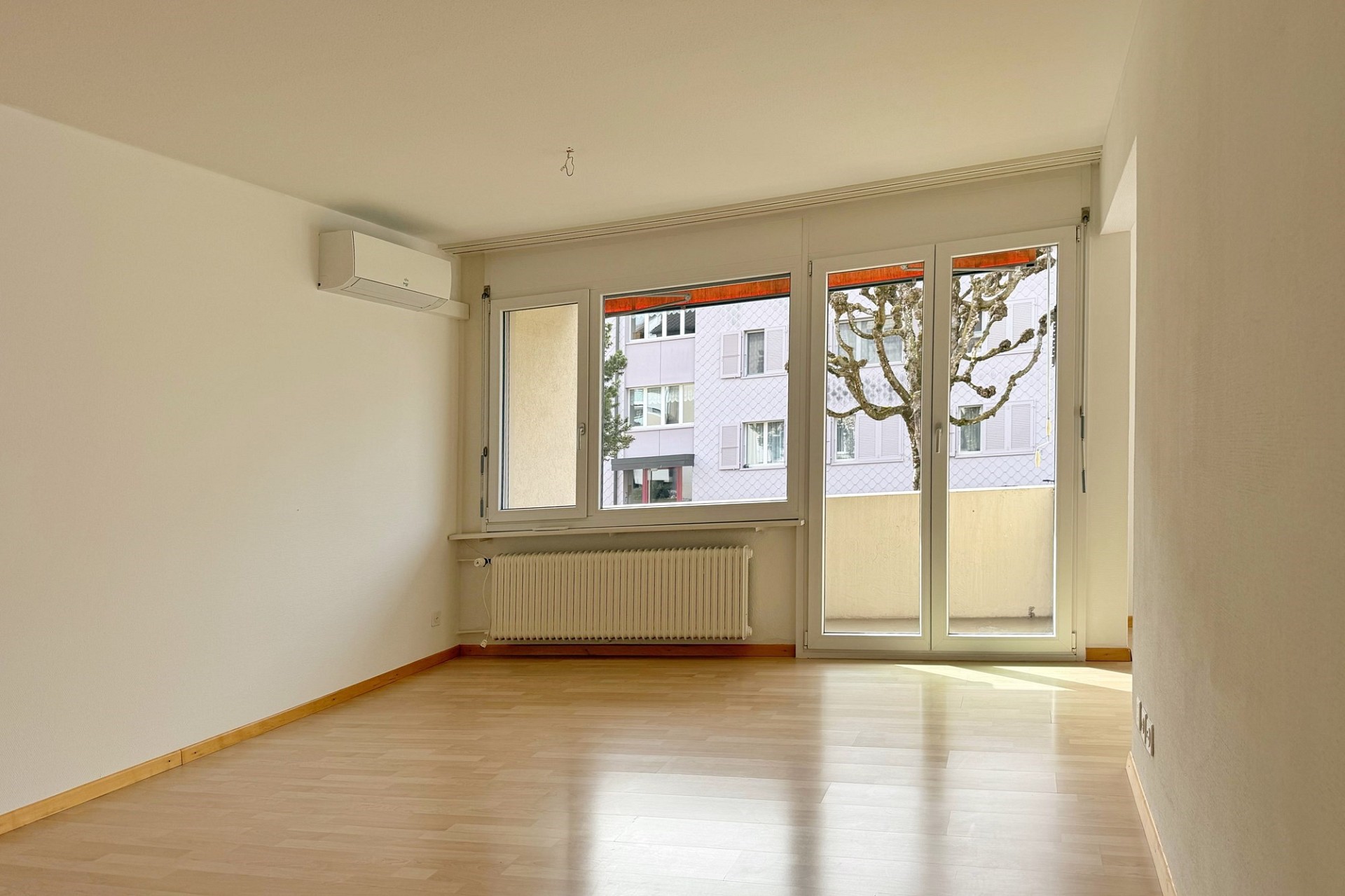 Helles leeres Zimmer mit Balkon und Klimagerät