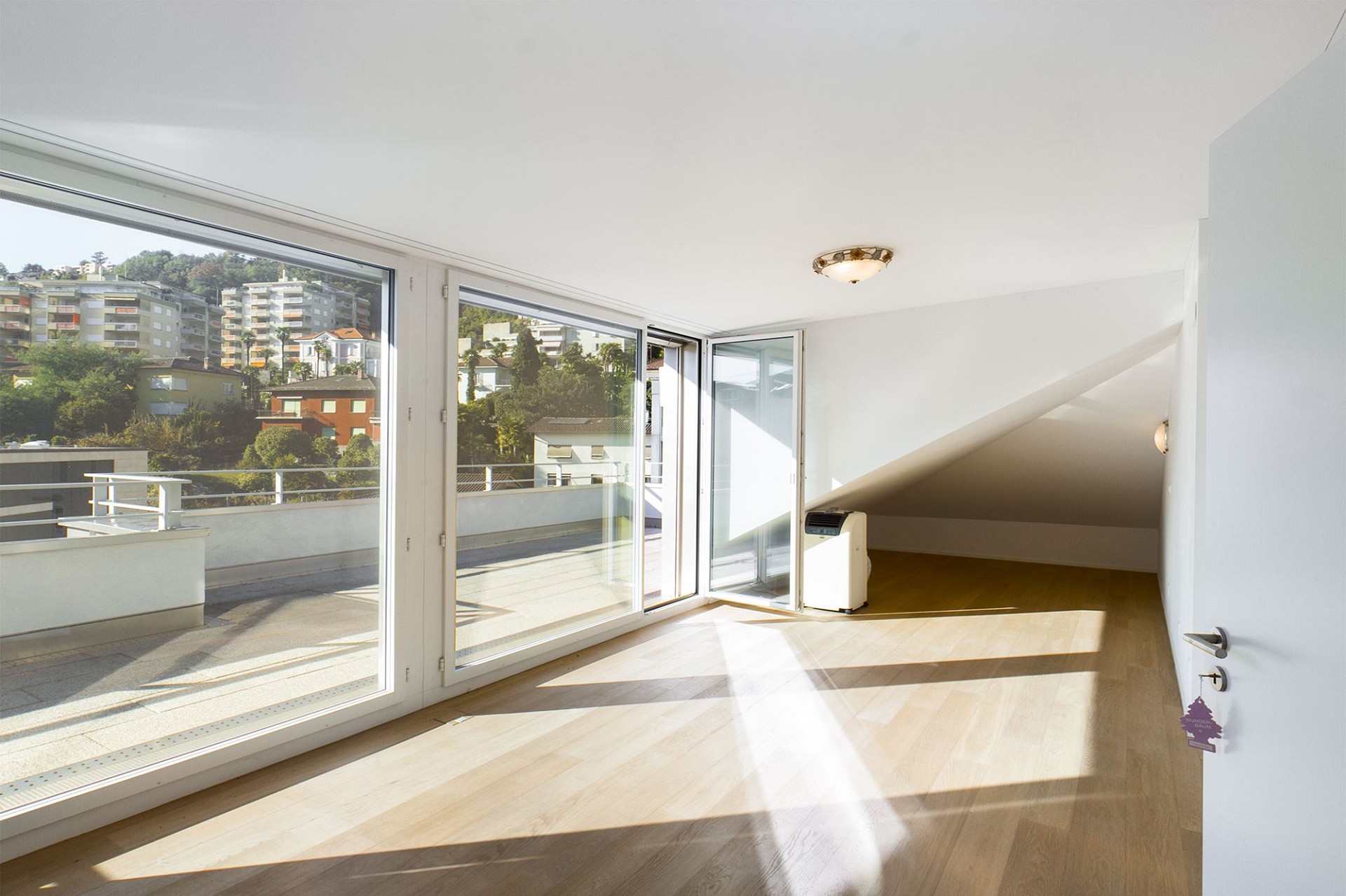 Heller Wohnraum mit großer Fensterfront und Terrasse