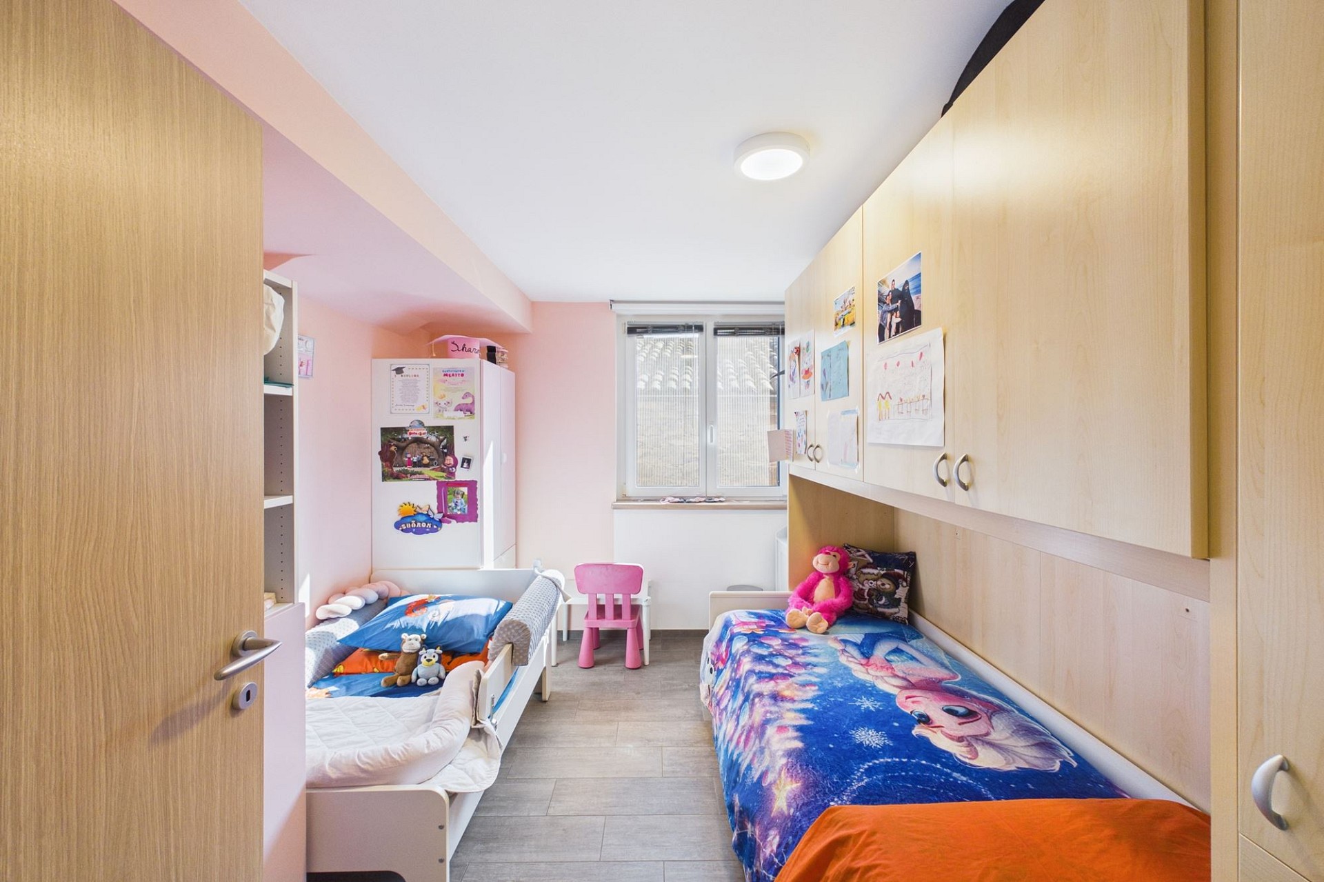 Kinderzimmer mit zwei Betten und Einbauschränken
