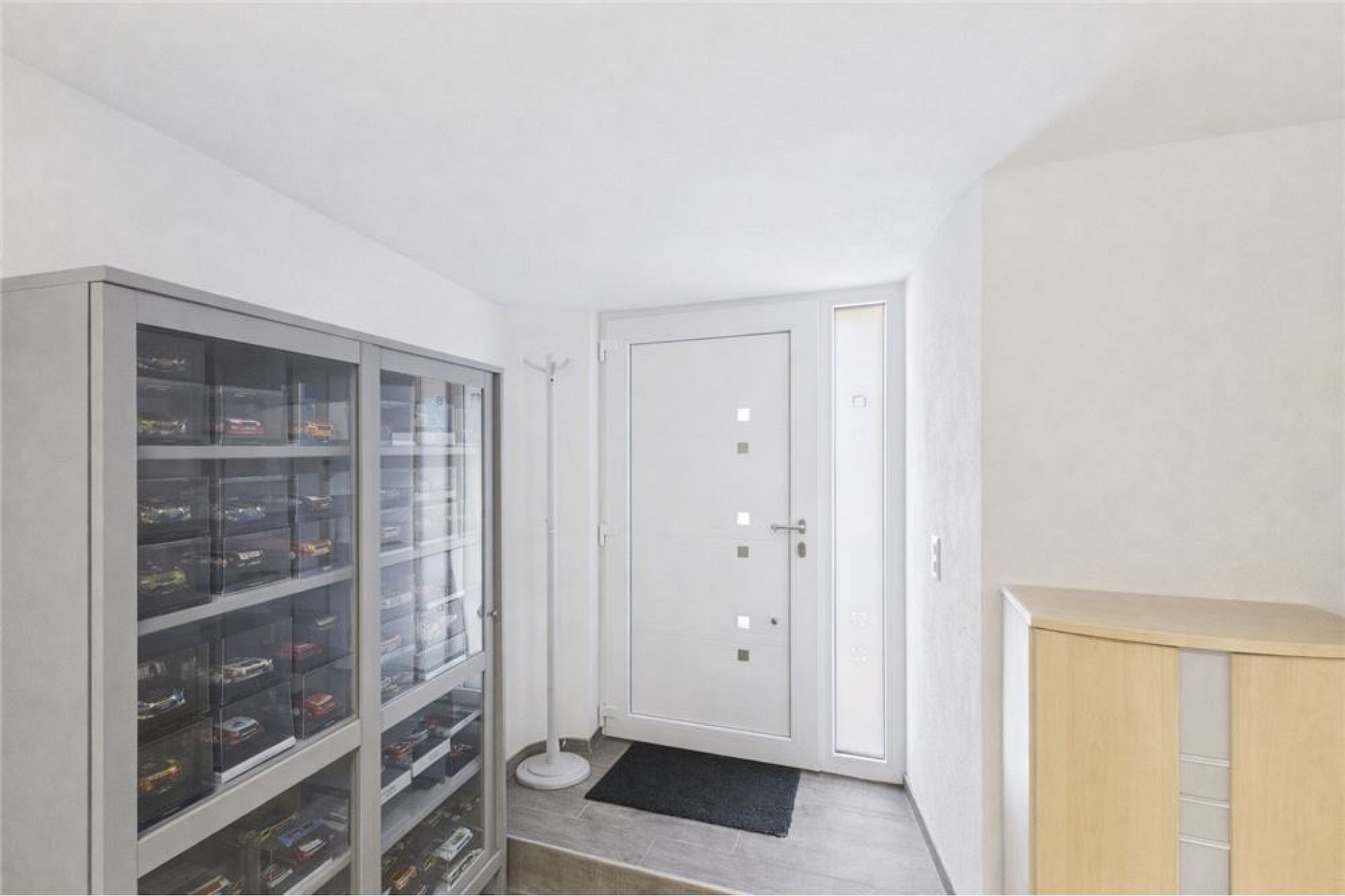 Heller Eingangsbereich mit Vitrenschrank