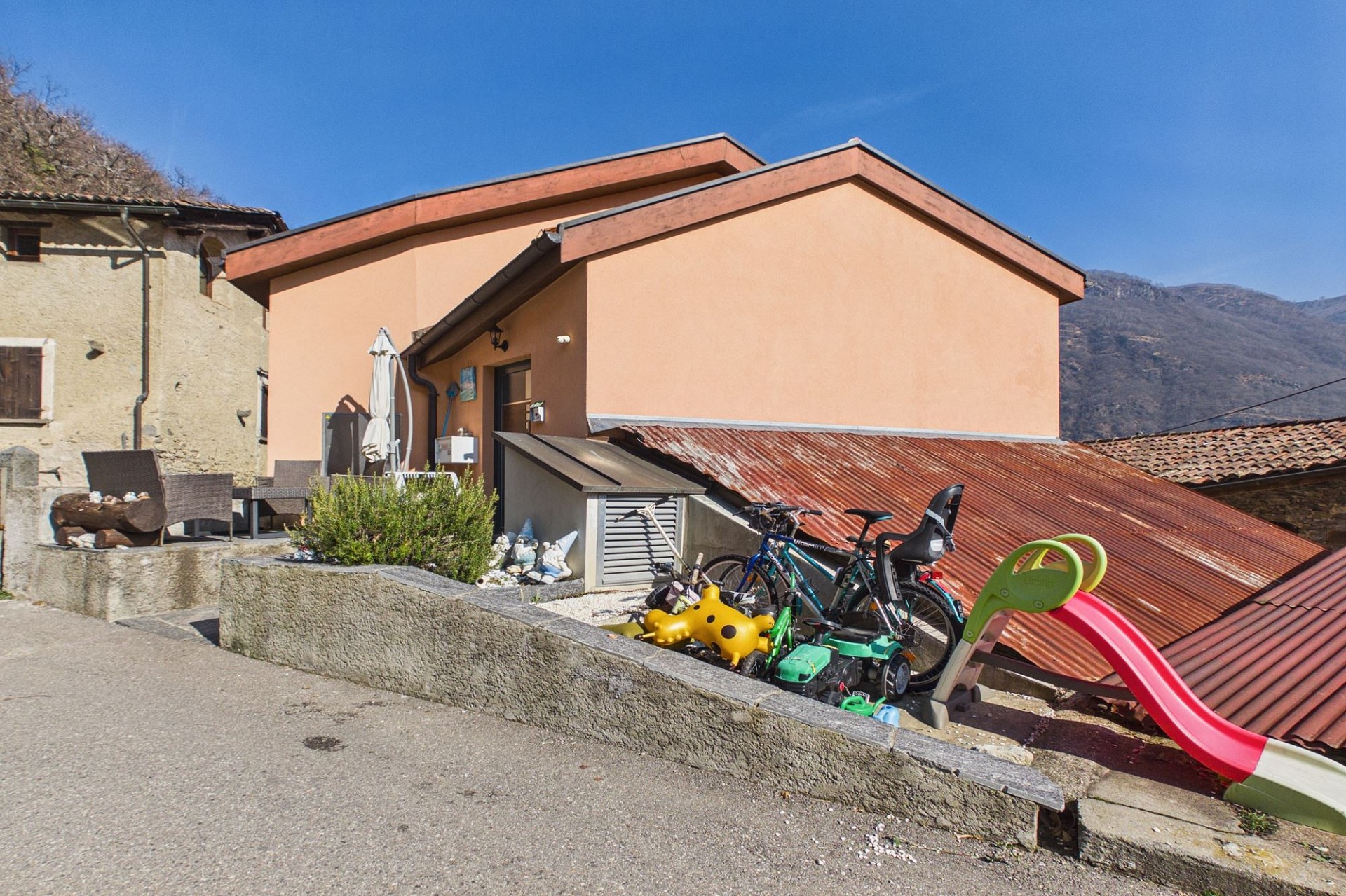 Außenansicht eines Hauses mit Terrasse und Spielbereich