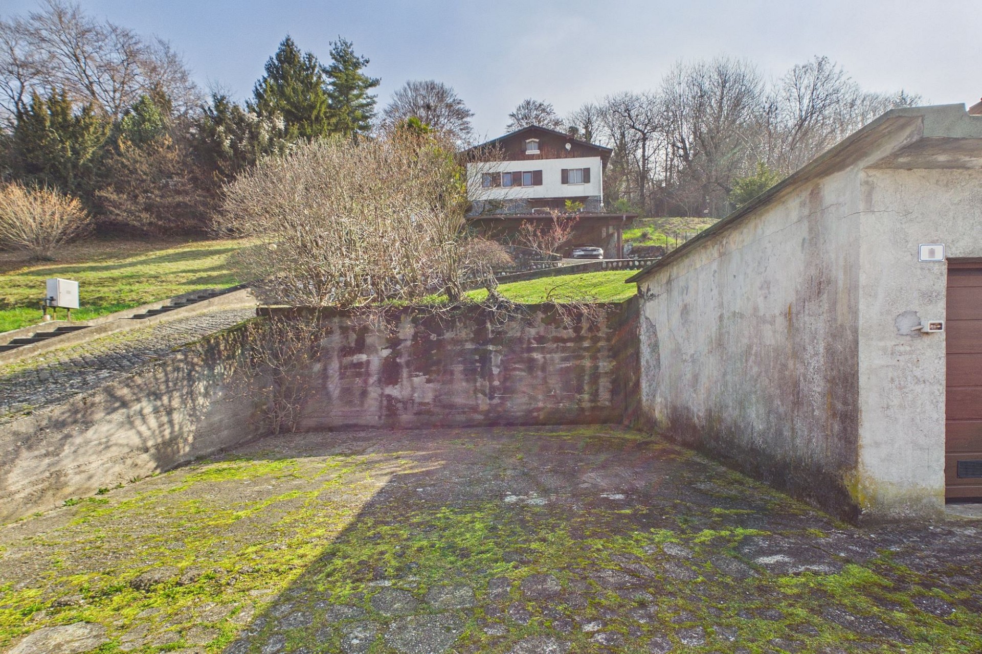 Außenansicht eines Grundstücks mit Einfahrt und Haus im Hintergrund