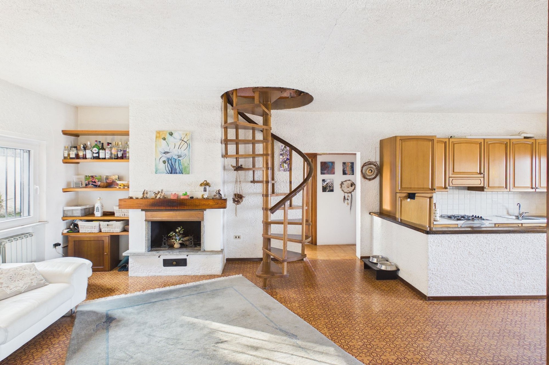 Wohnzimmer mit offener Küche und Wendeltreppe