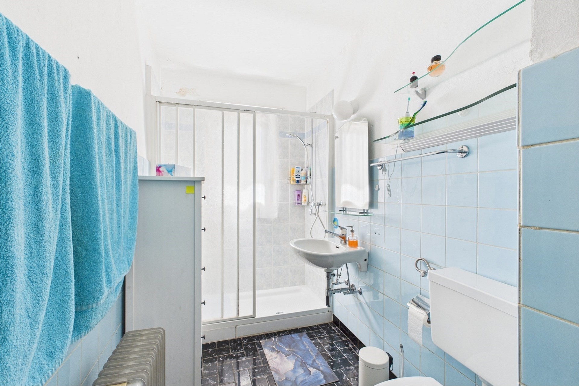 Kleines Badezimmer mit hellblauen Fliesen