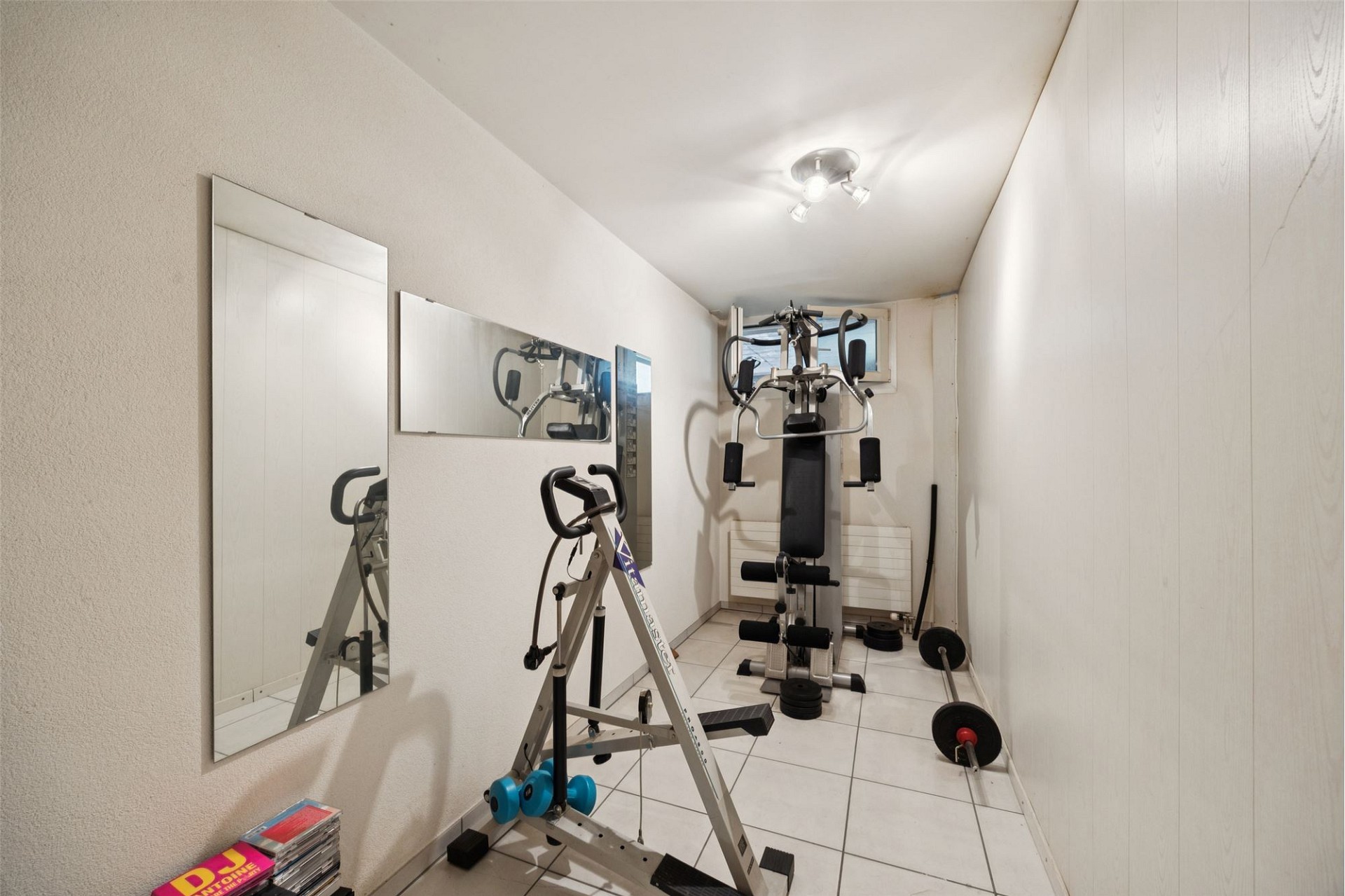 Heller Fitnessraum in schmalem Nebenraum